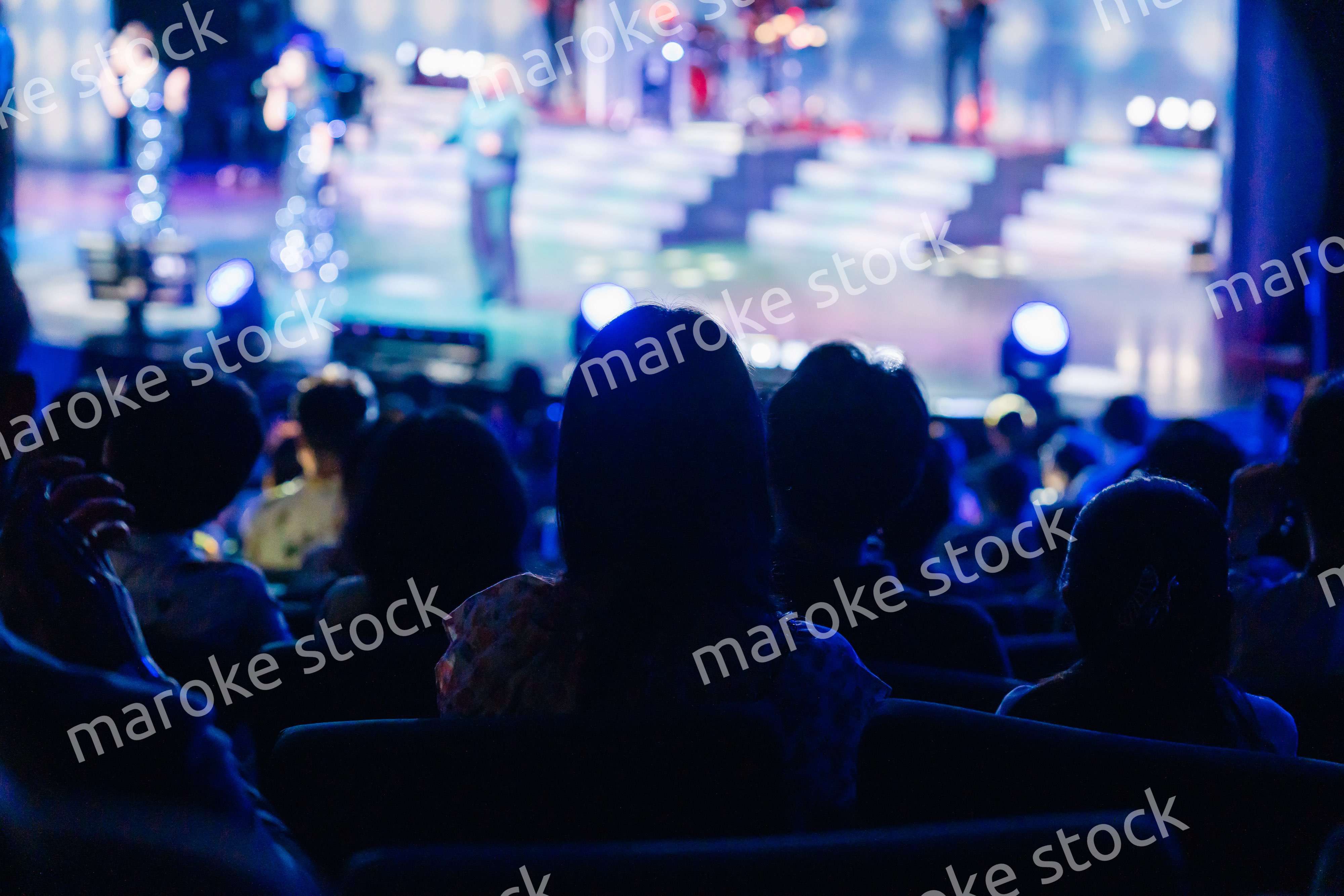 ホールでライブパフォーマンスを鑑賞する客