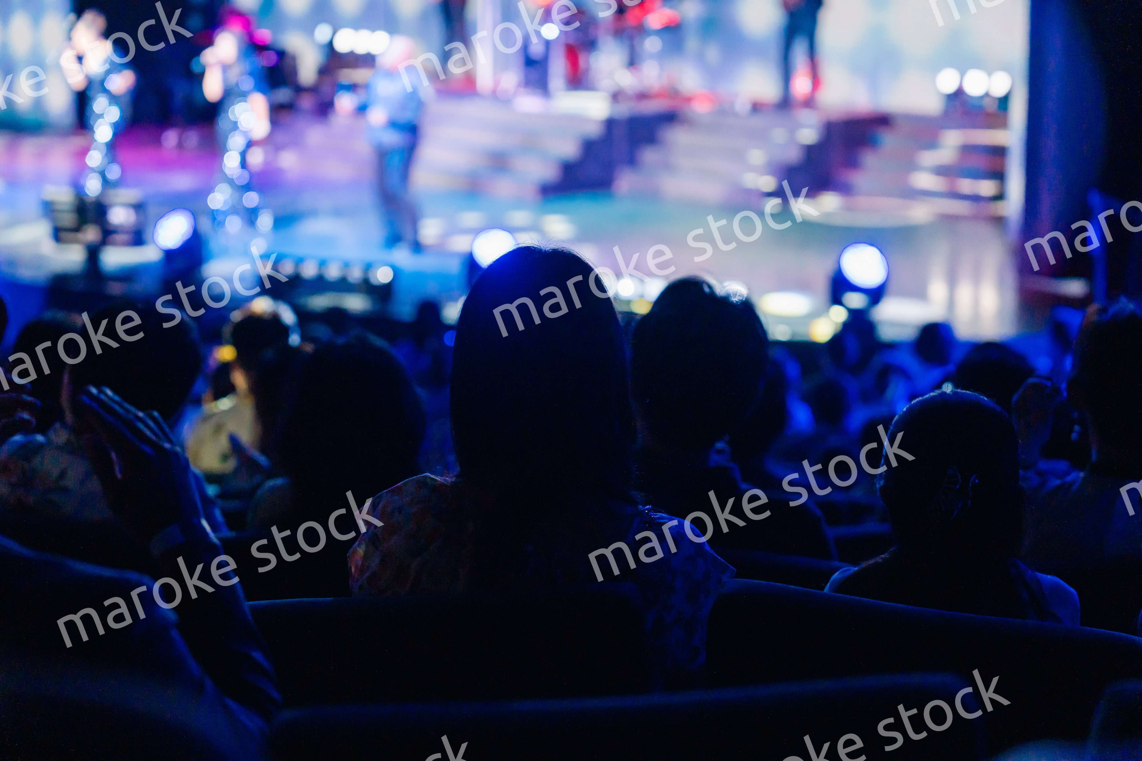 ホールでライブパフォーマンスを鑑賞する客