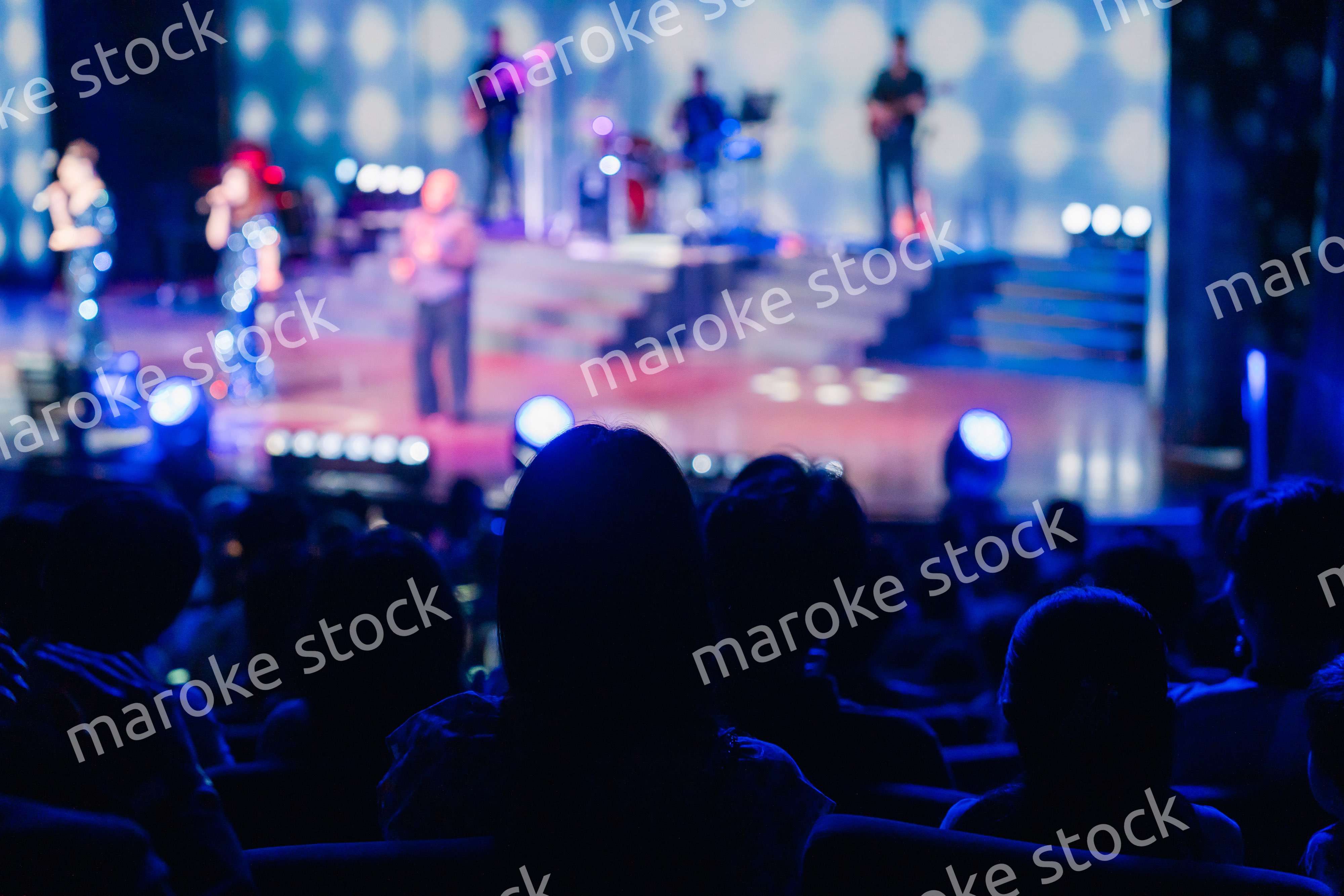 ホールでライブパフォーマンスを鑑賞する客