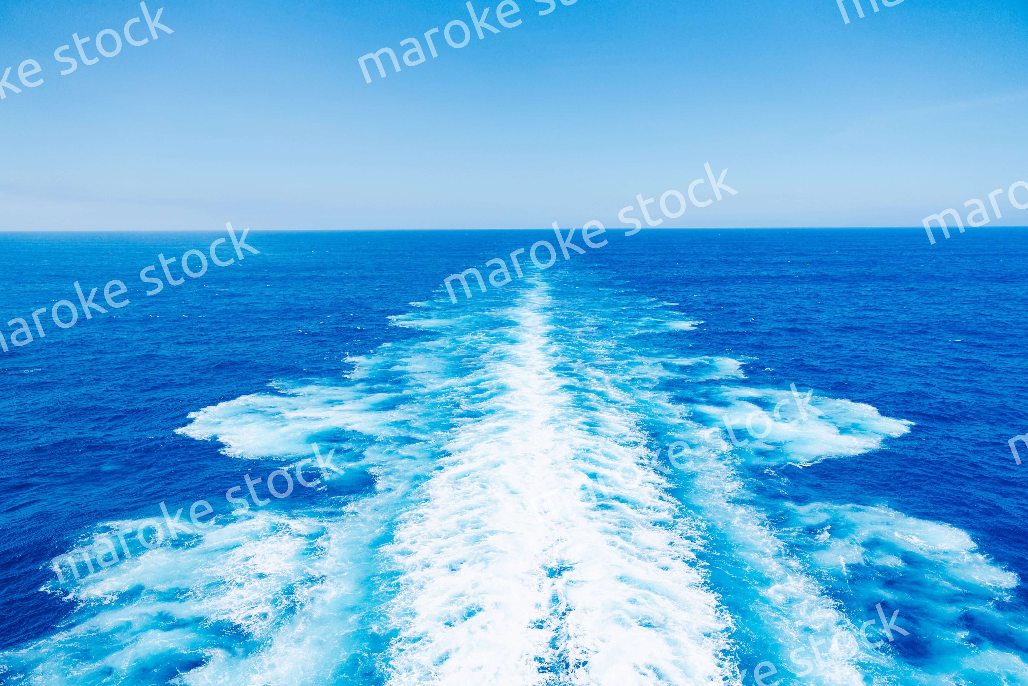 波しぶきを上げて航海をする大型船