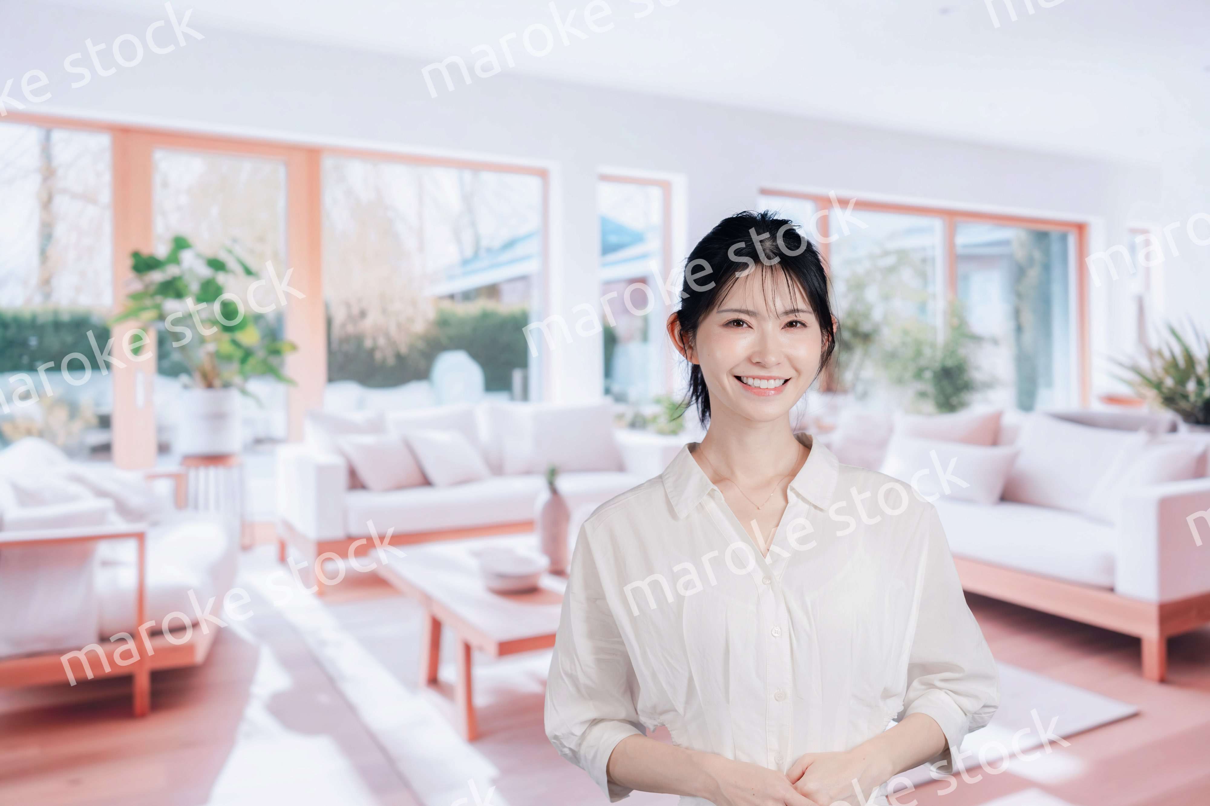 明るいリビングで過ごす若い女性