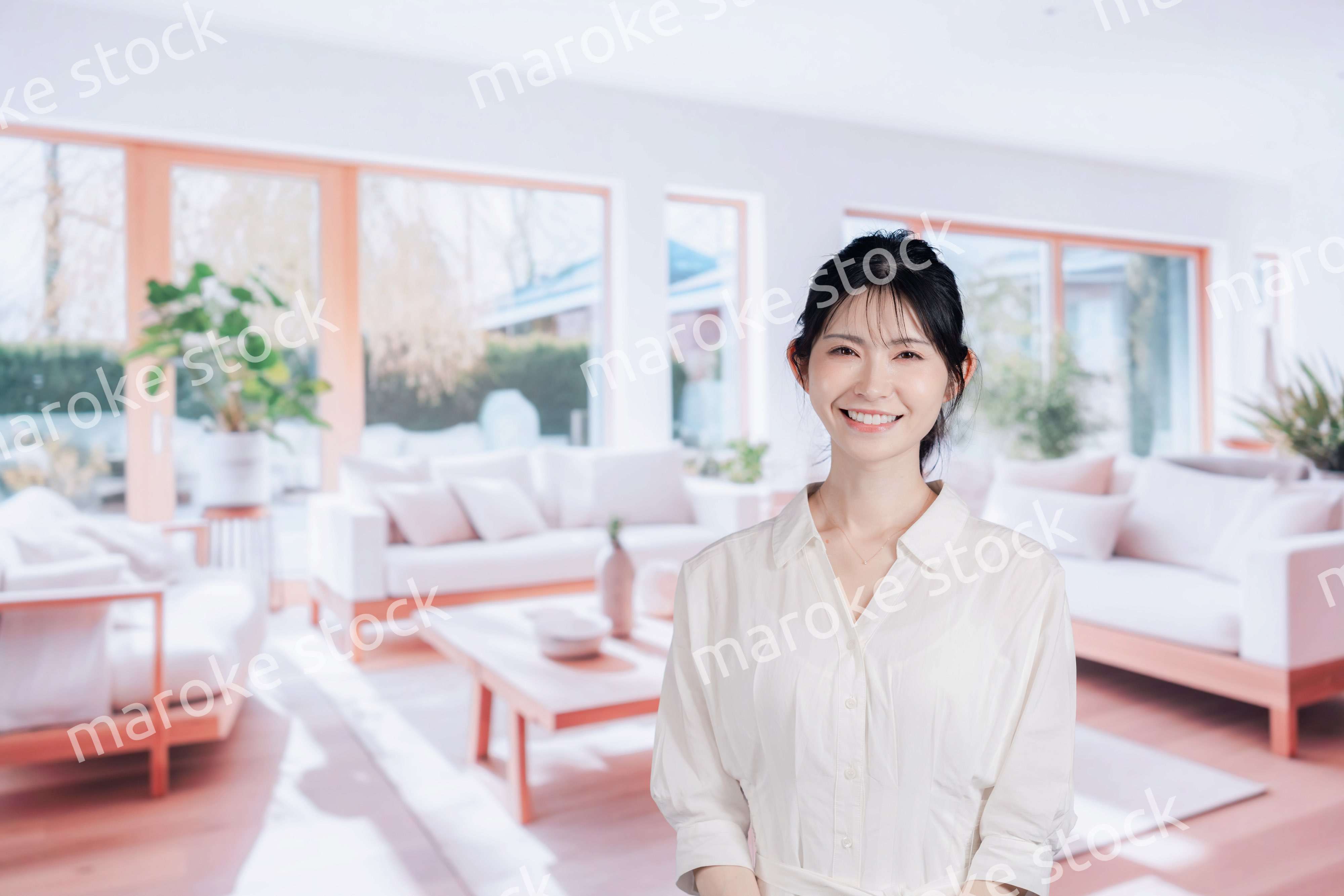 明るいリビングで過ごす若い女性