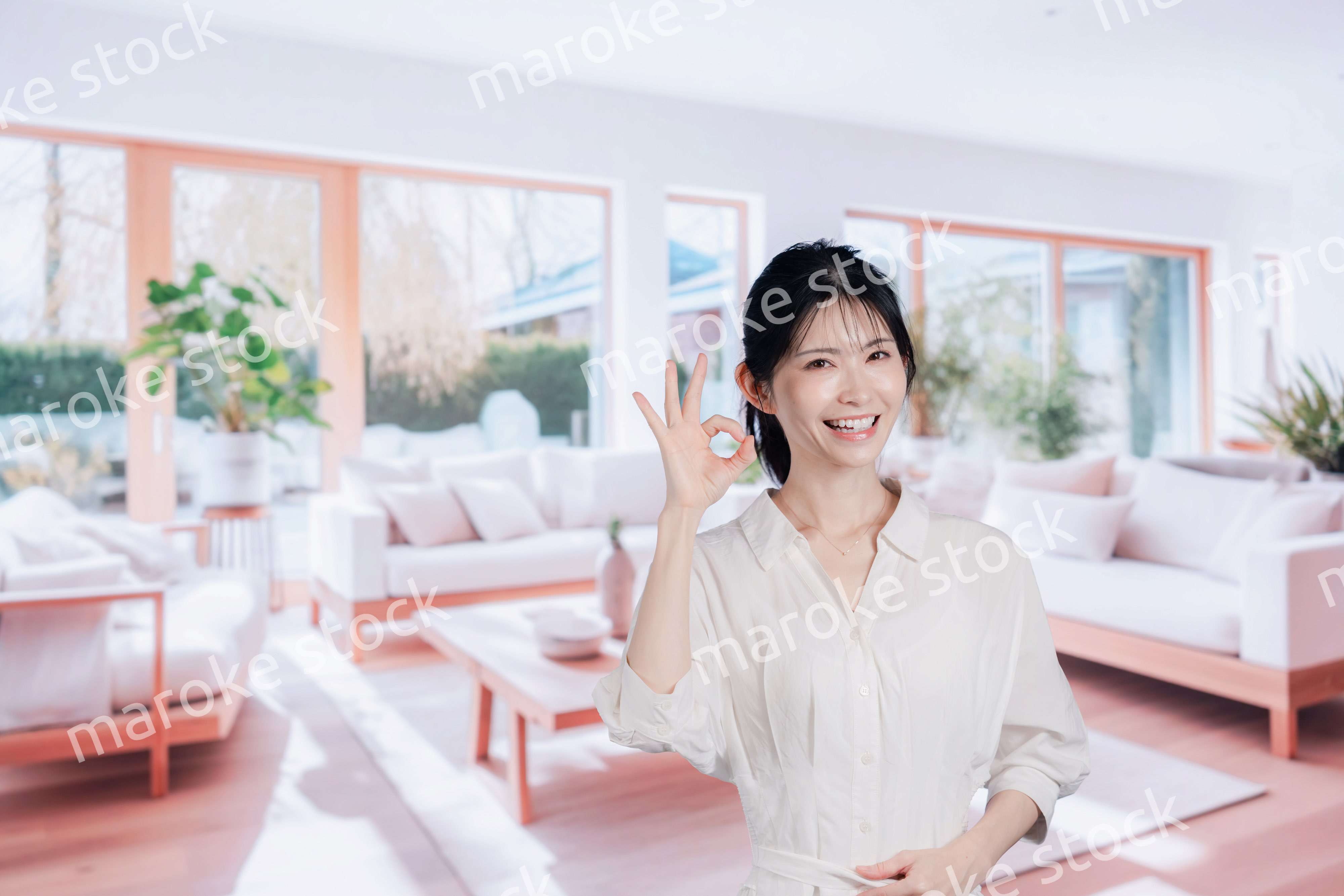 明るいリビングで過ごす若い女性