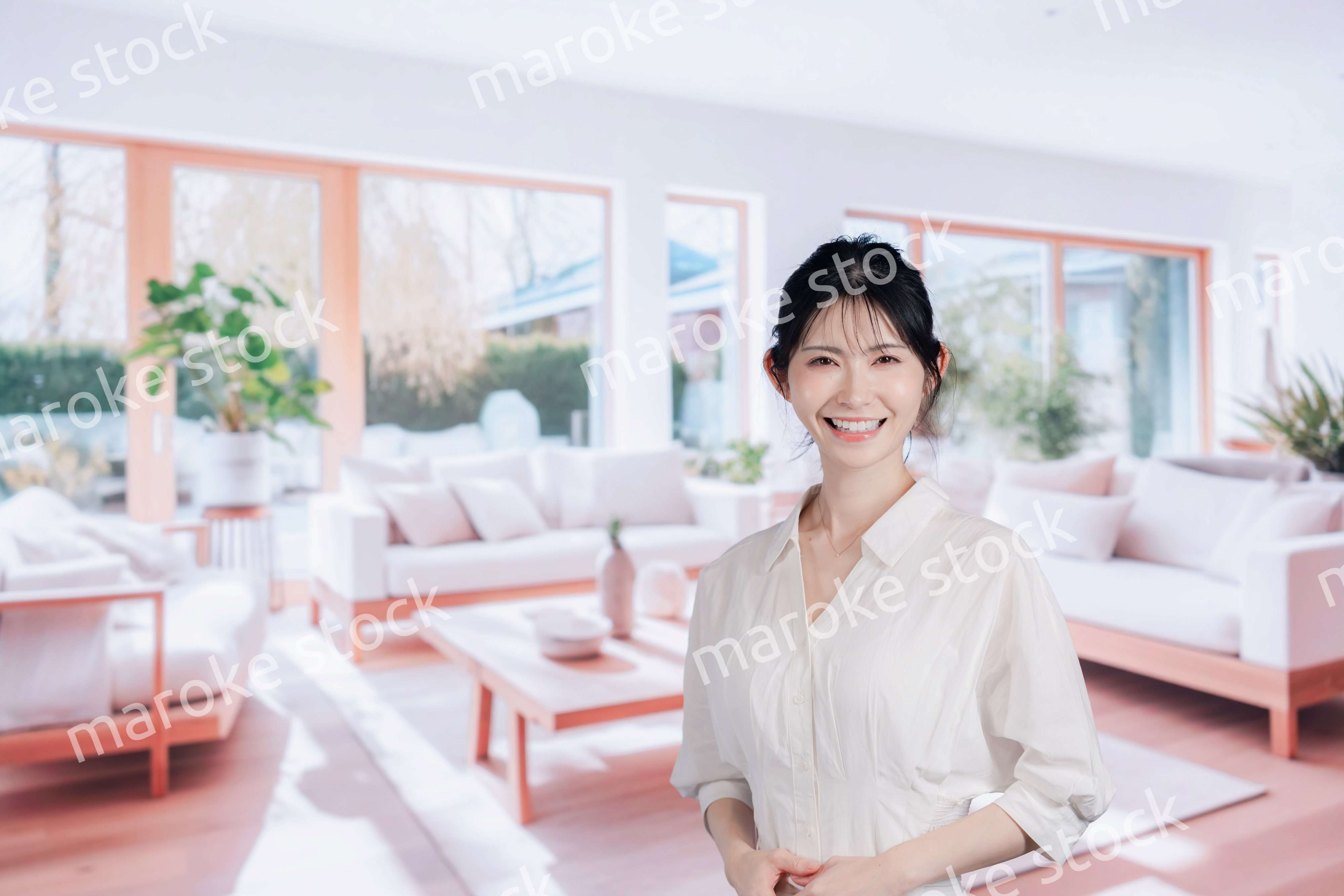 明るいリビングで過ごす若い女性
