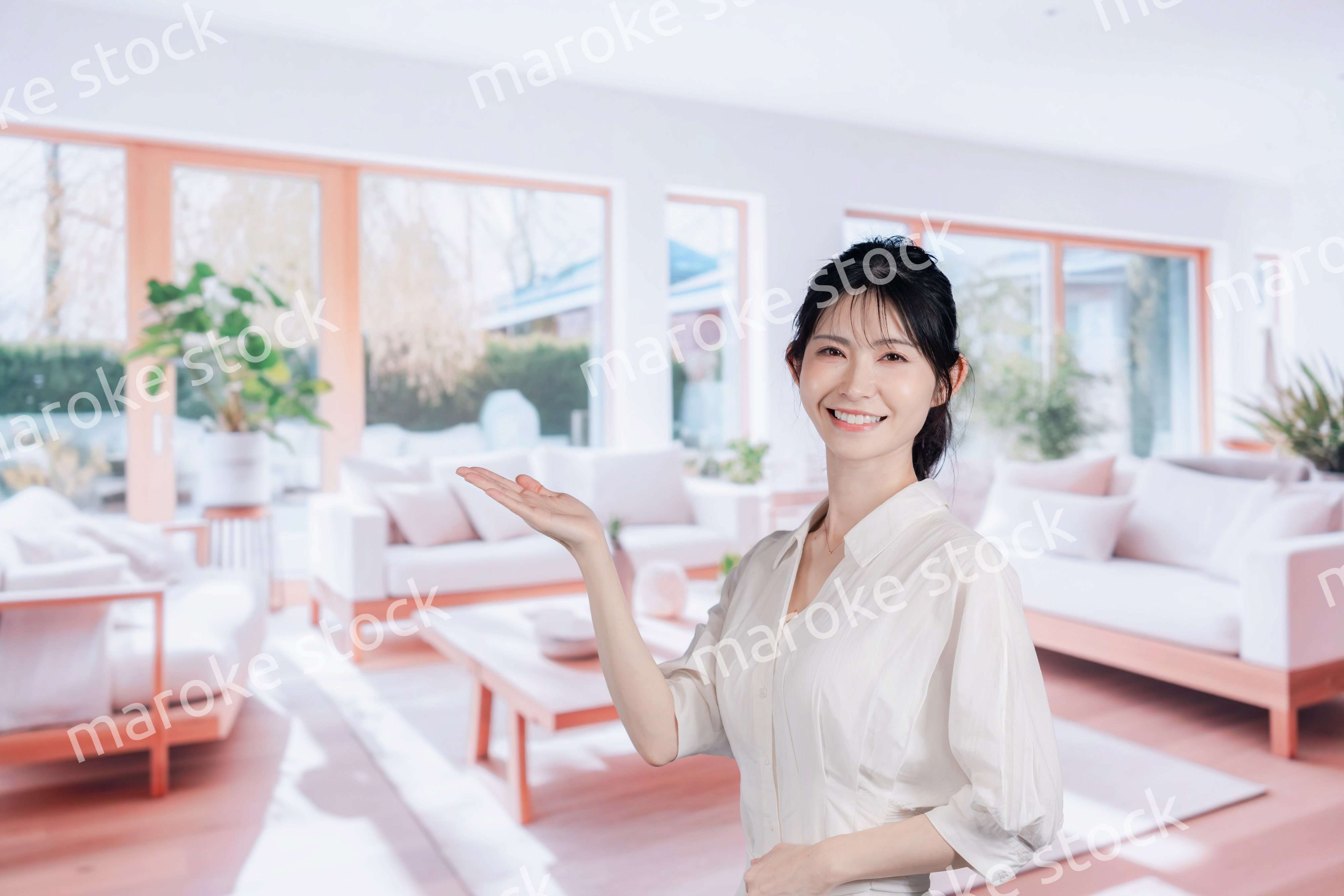 明るいリビングで過ごす若い女性