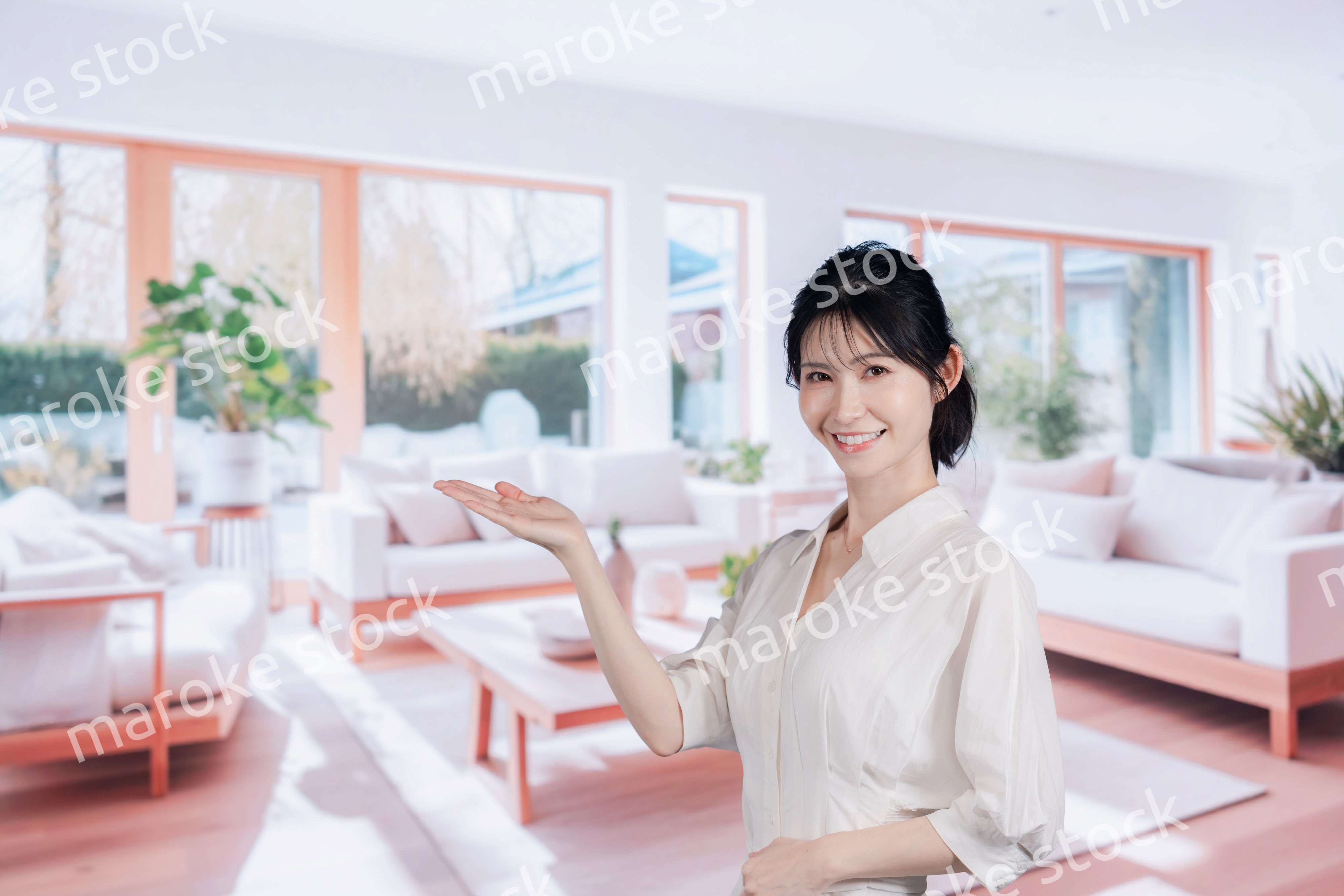 明るいリビングで過ごす若い女性