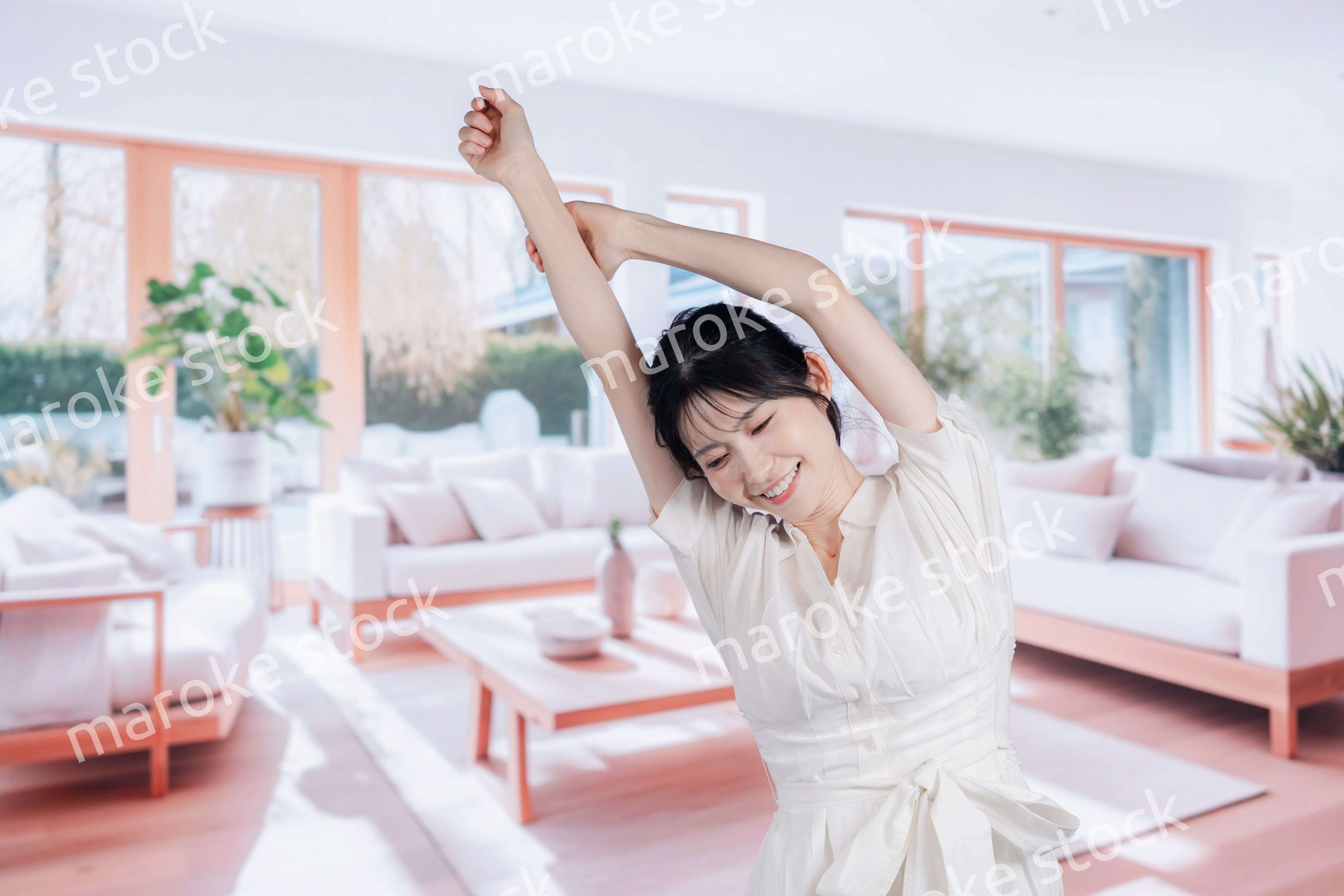 明るいリビングで過ごす若い女性