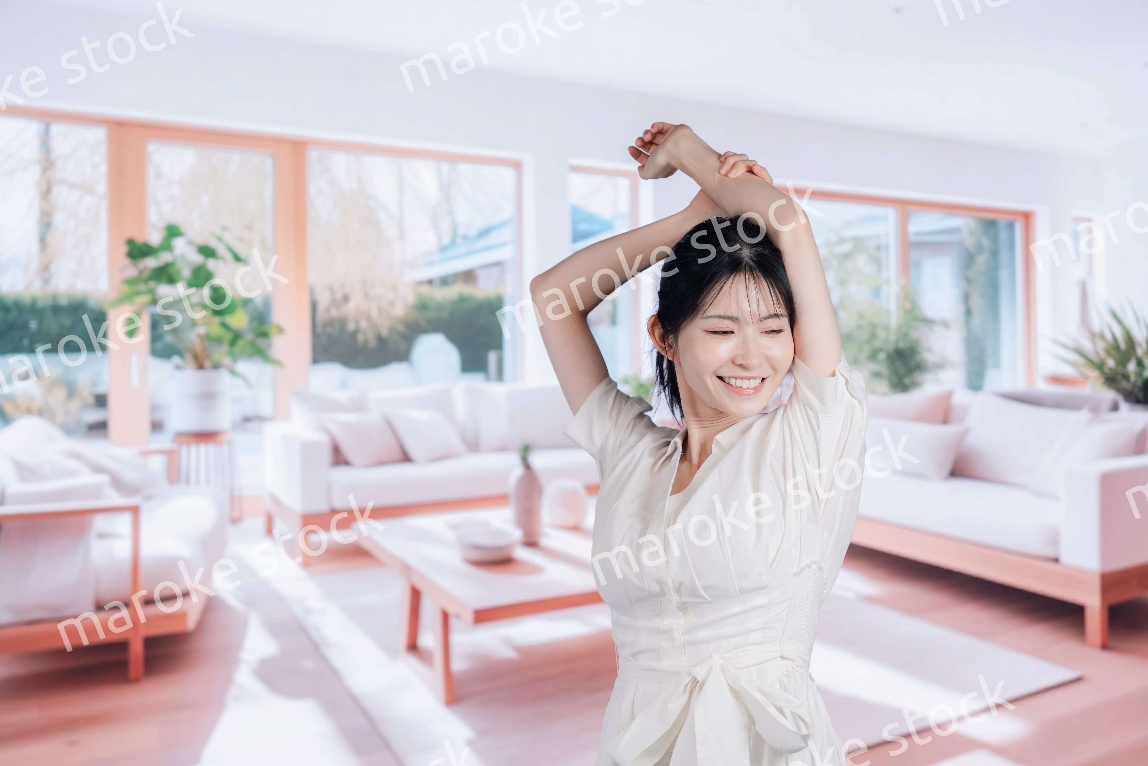明るいリビングで過ごす若い女性