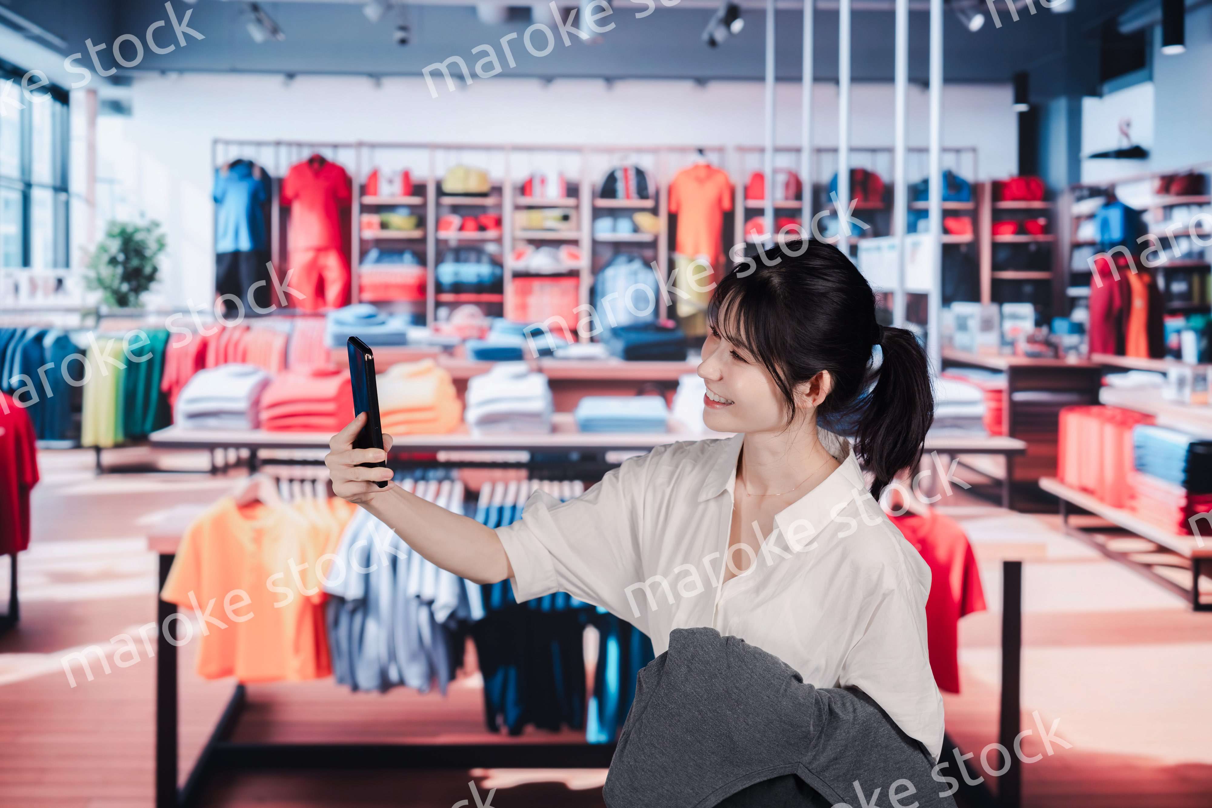 服屋さんで買い物をする若い女性