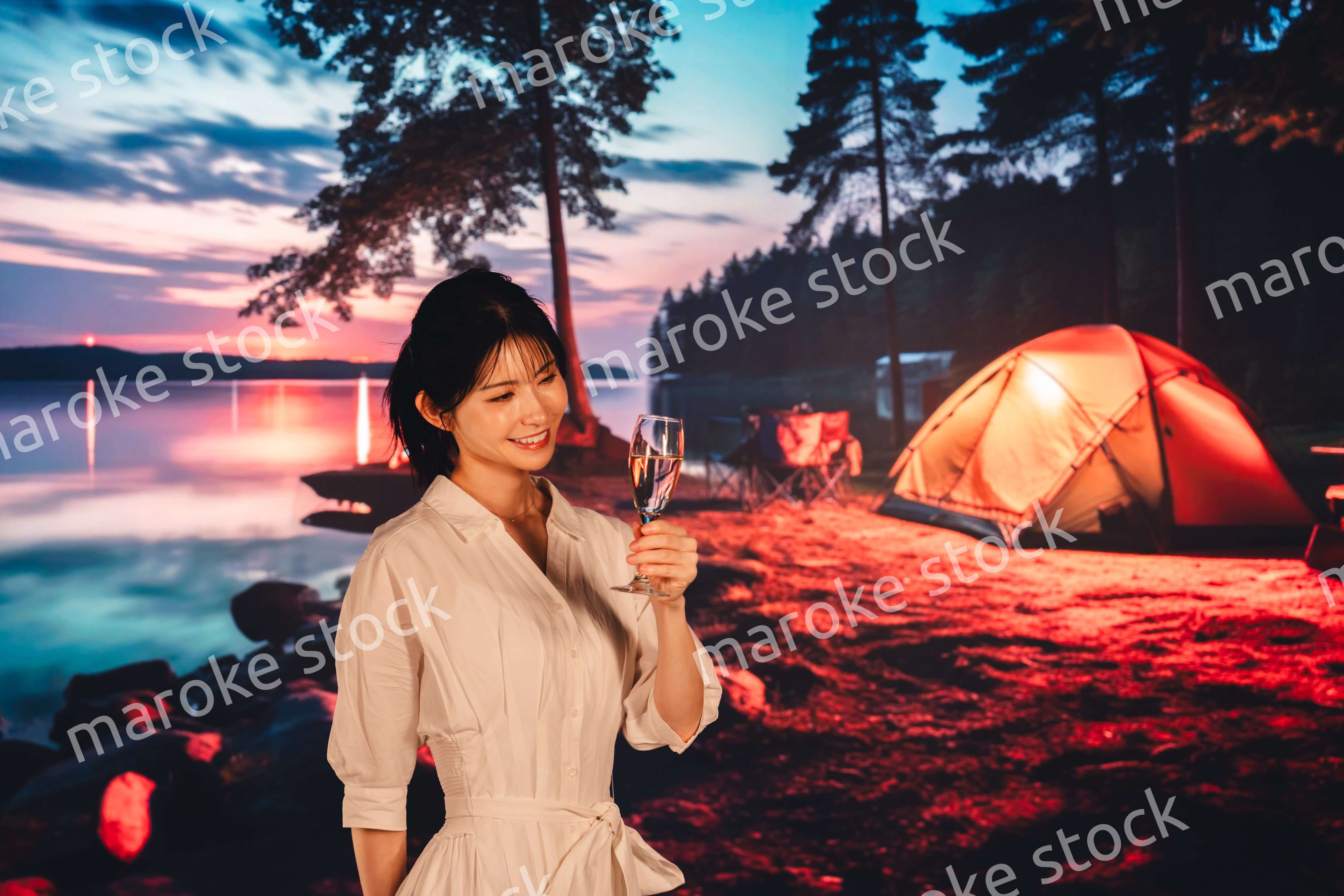 キャンプをしながらお酒を飲む若い女性