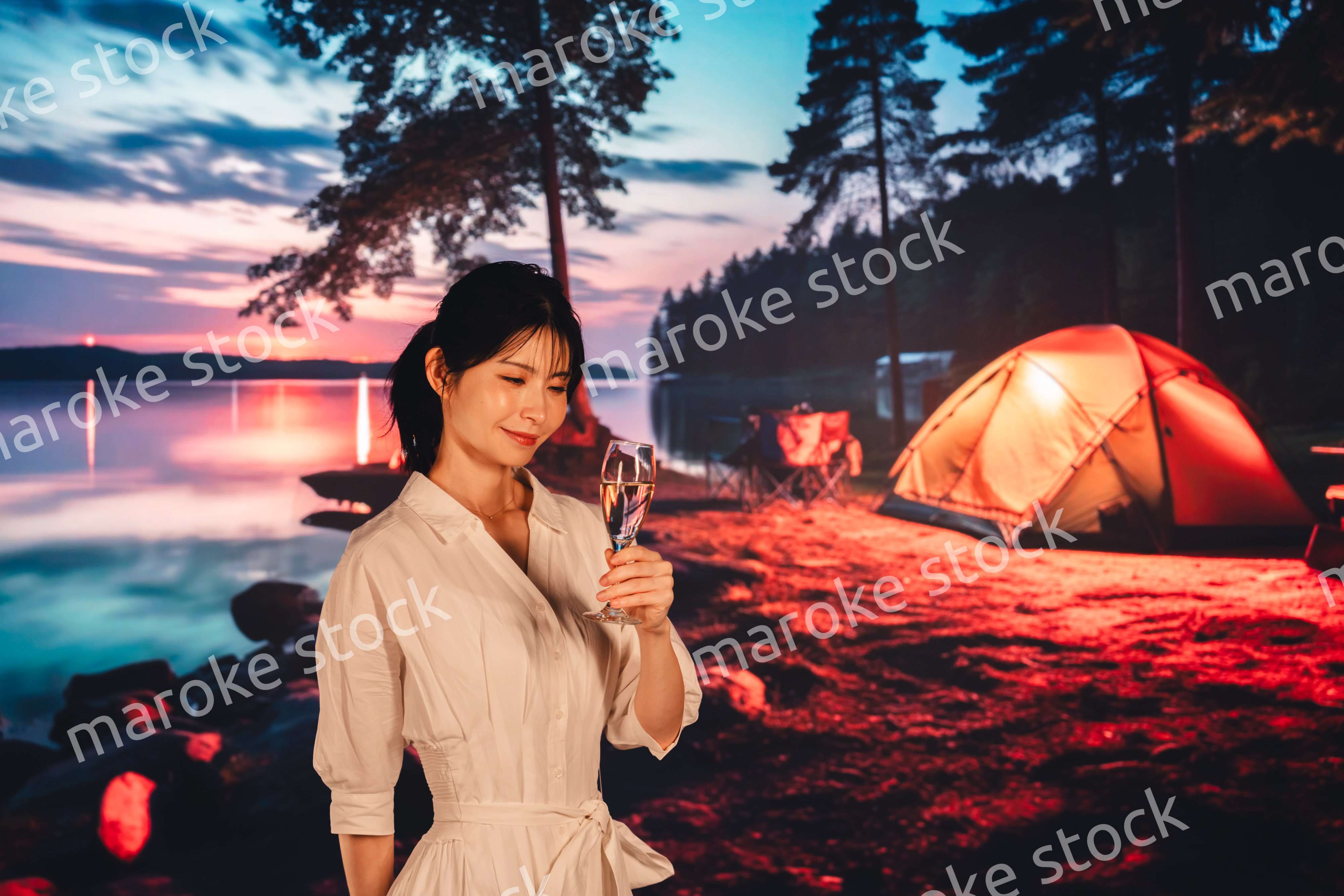 キャンプをしながらお酒を飲む若い女性