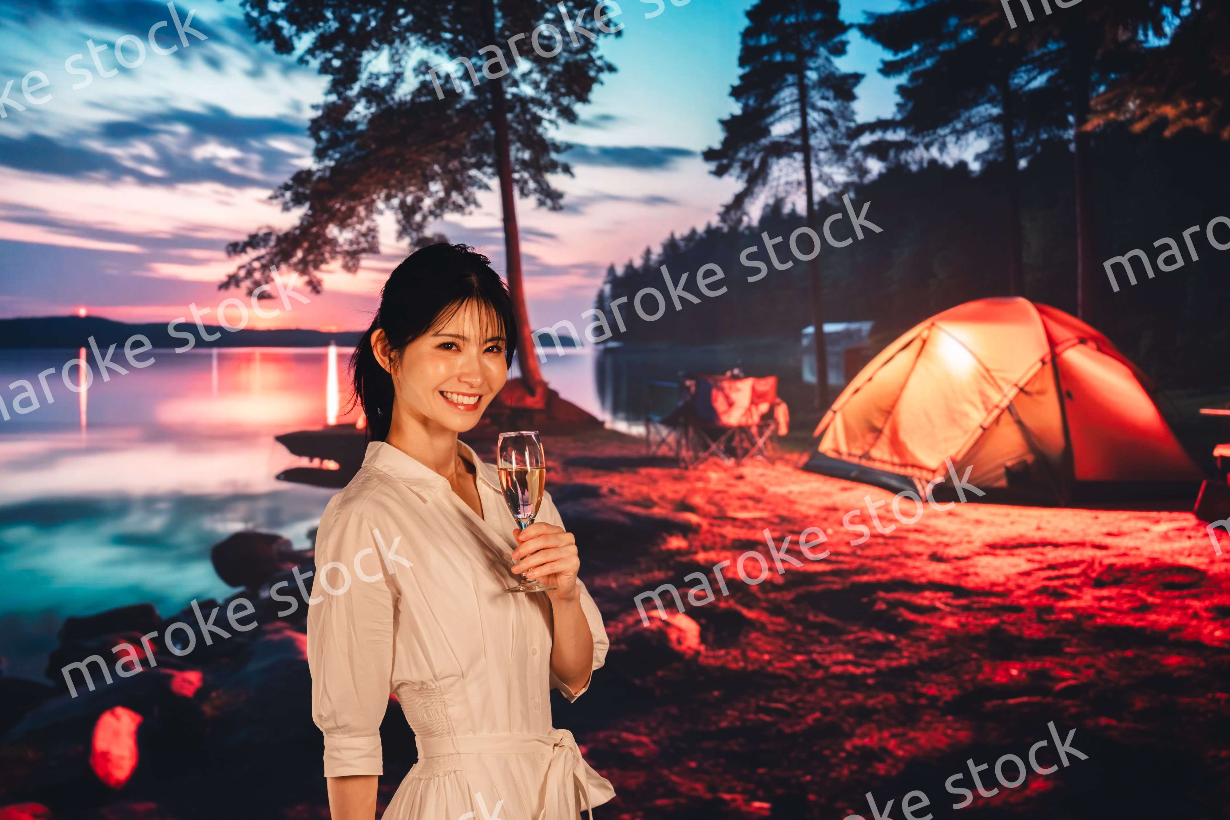 キャンプをしながらお酒を飲む若い女性