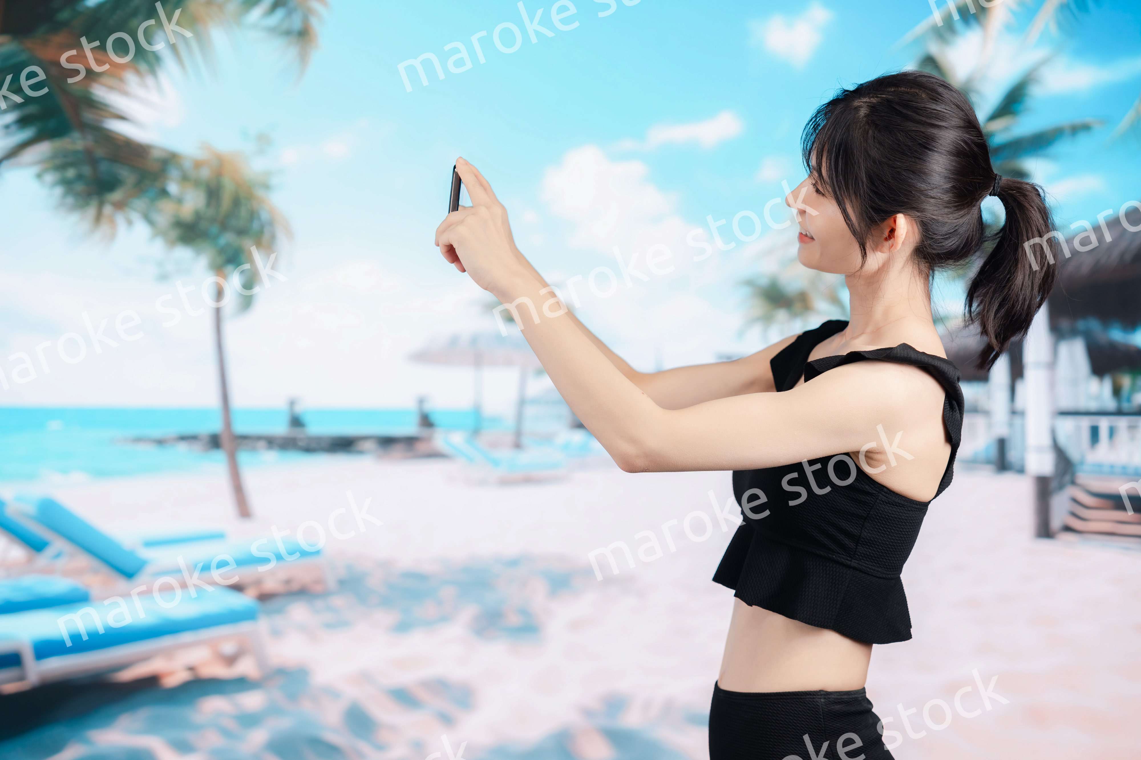 ビーチで自撮りをする若い女性