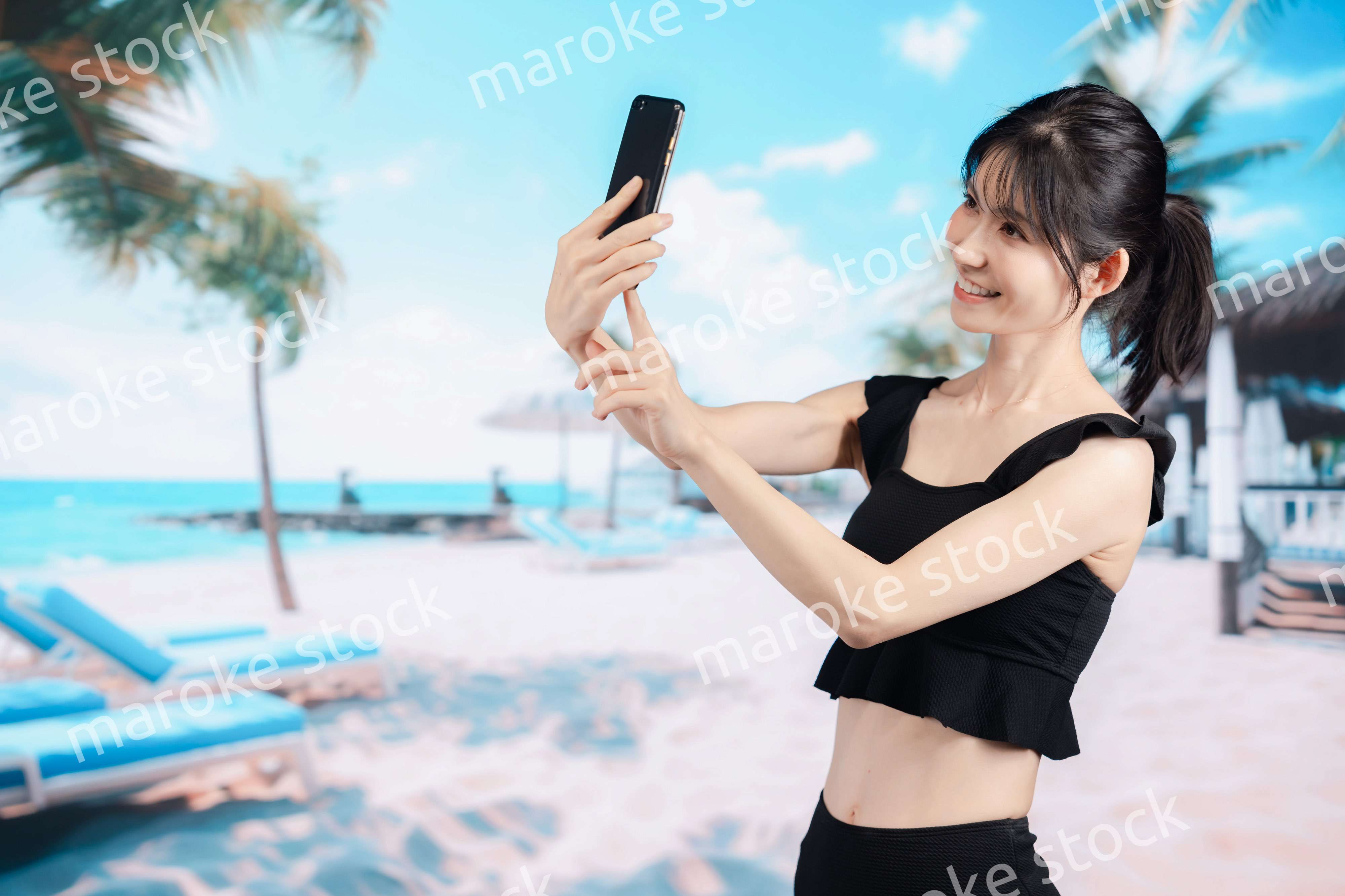 ビーチで自撮りをする若い女性