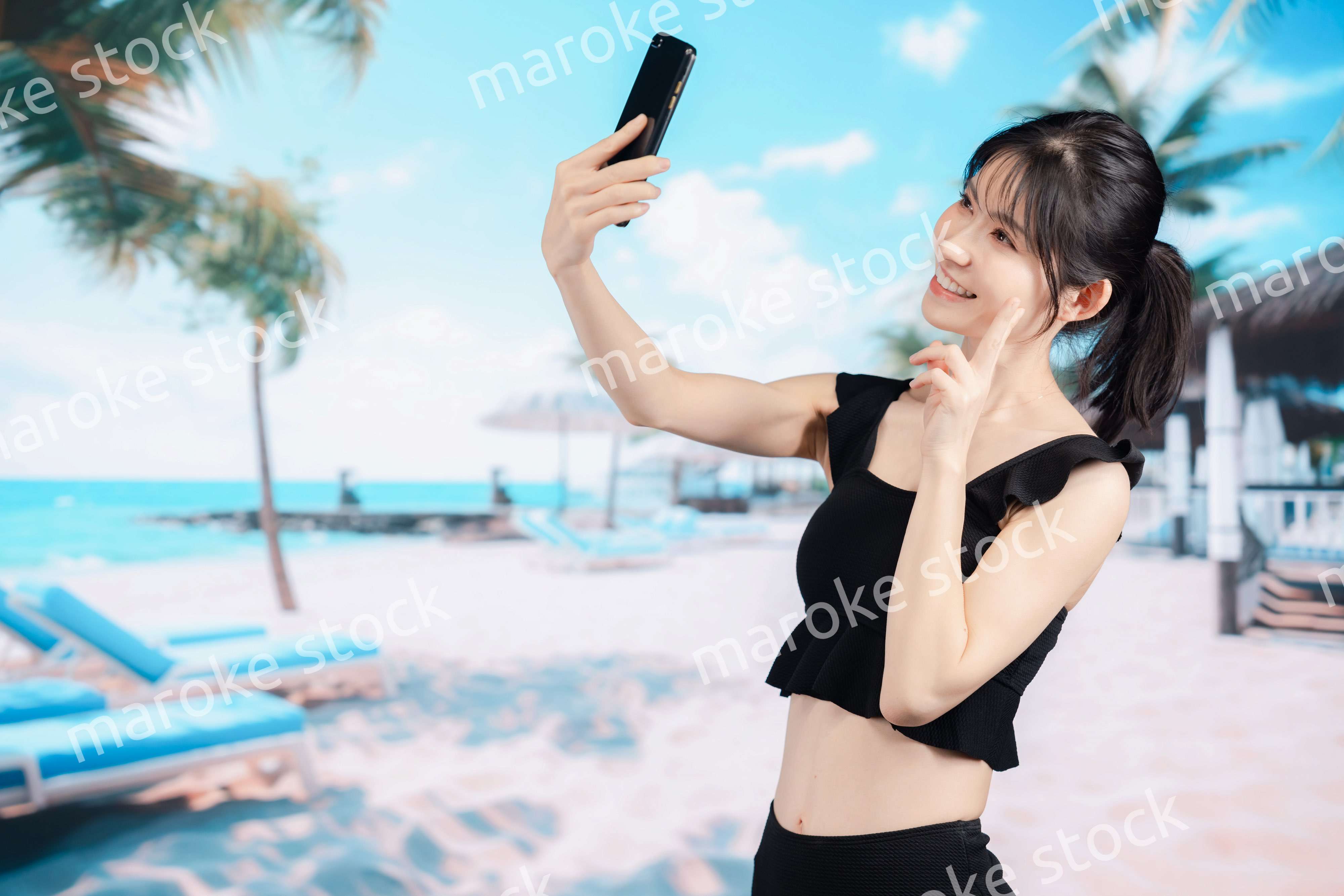 ビーチで自撮りをする若い女性