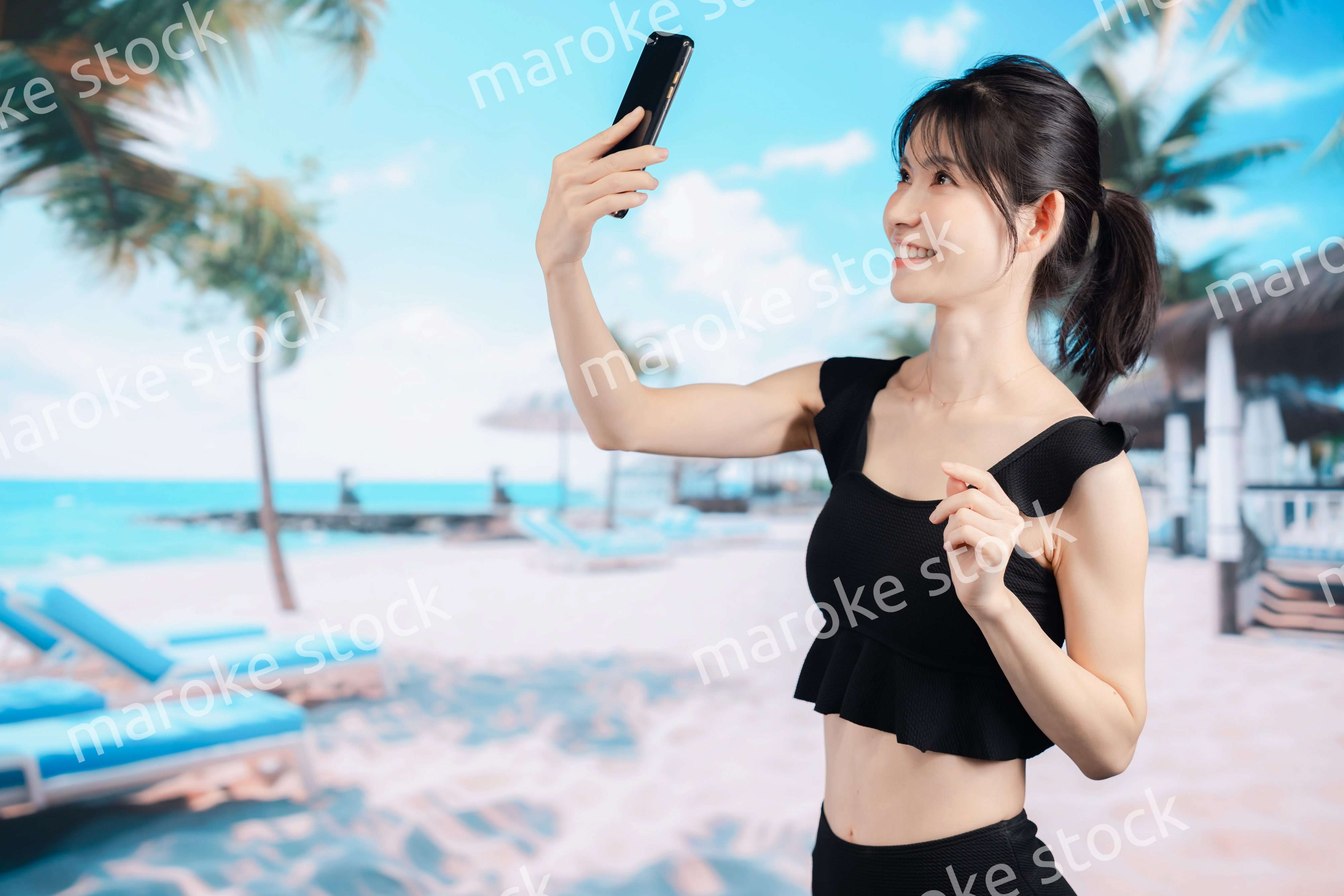 ビーチで自撮りをする若い女性