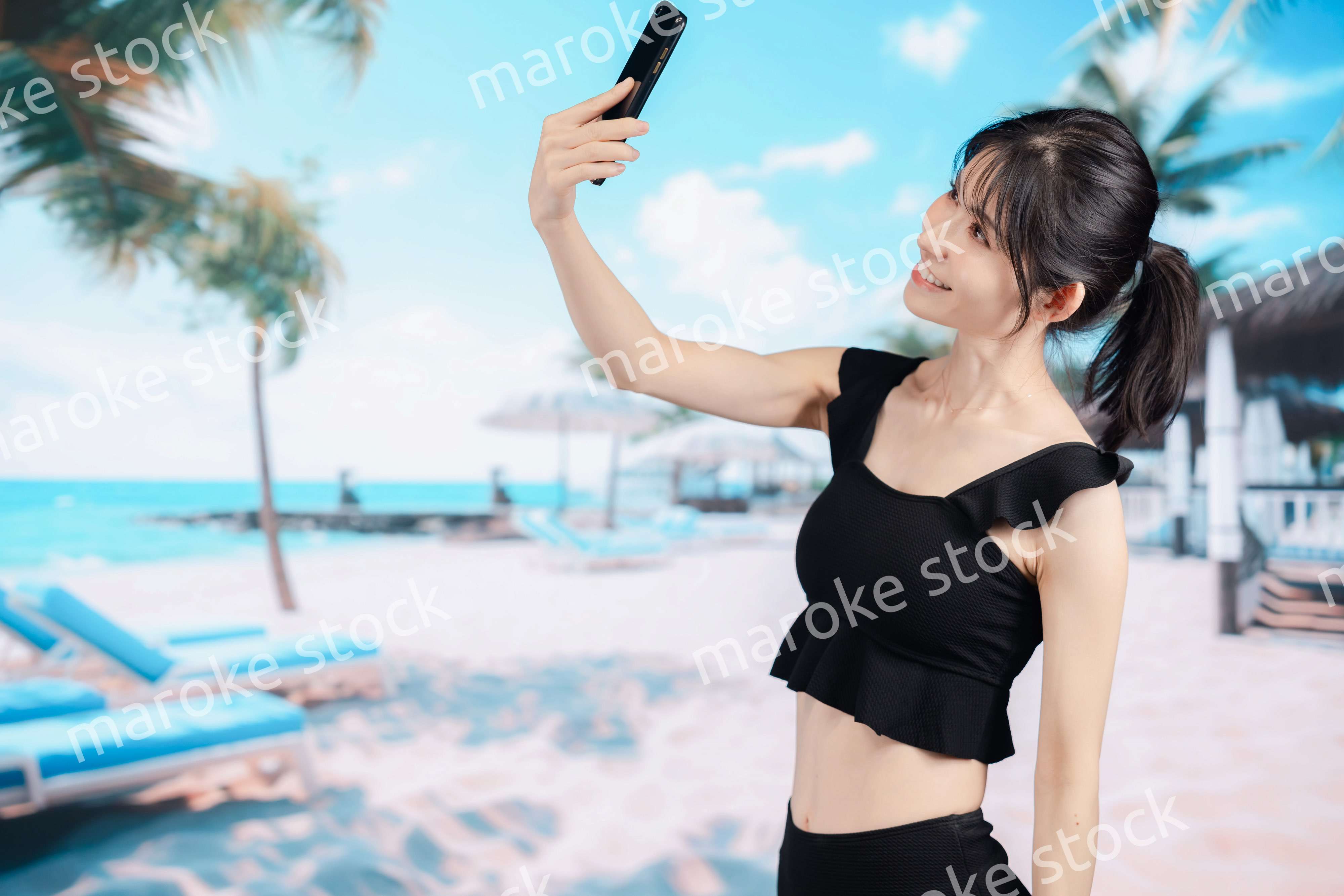 ビーチで自撮りをする若い女性