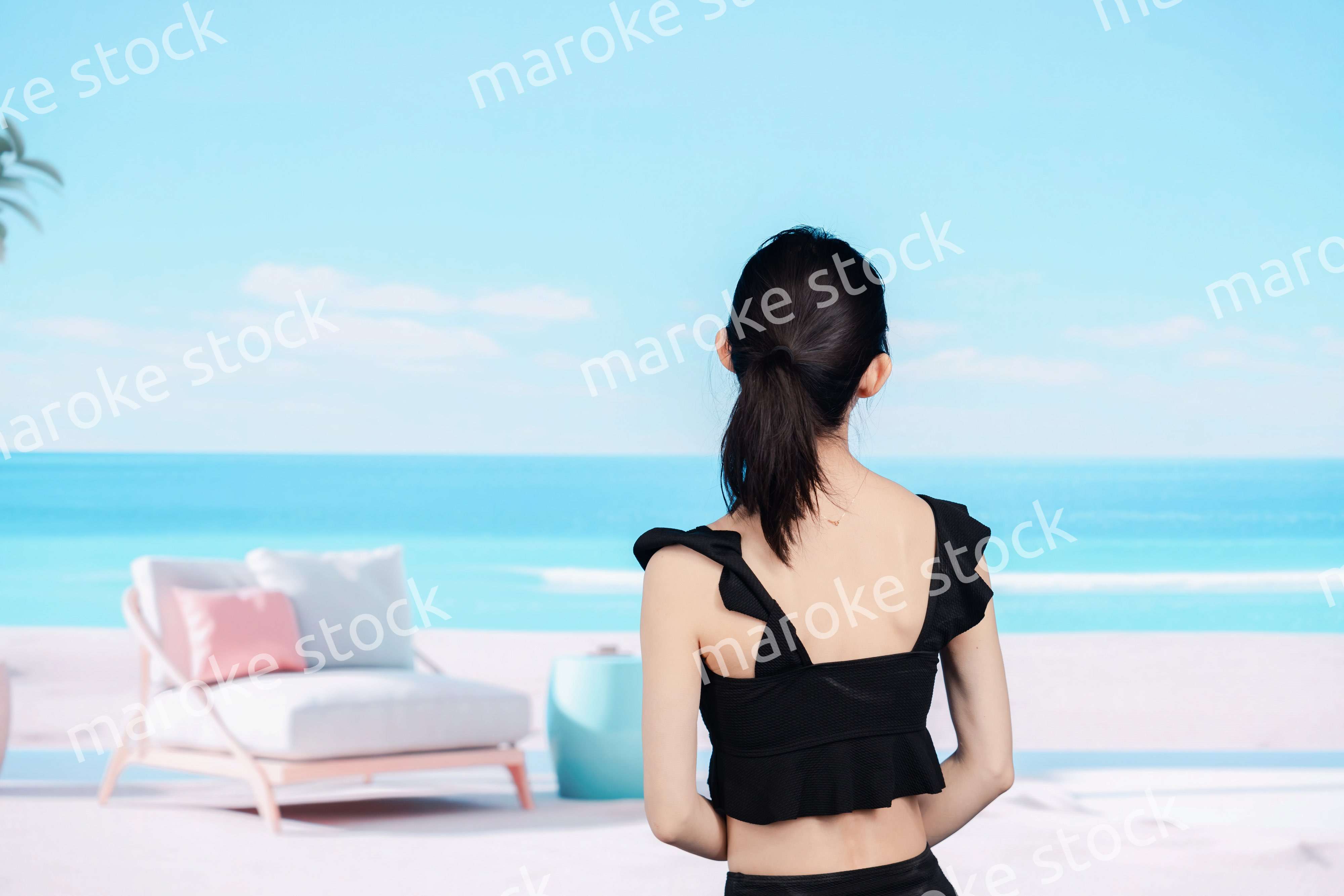 水着を着て海を眺める若い女性