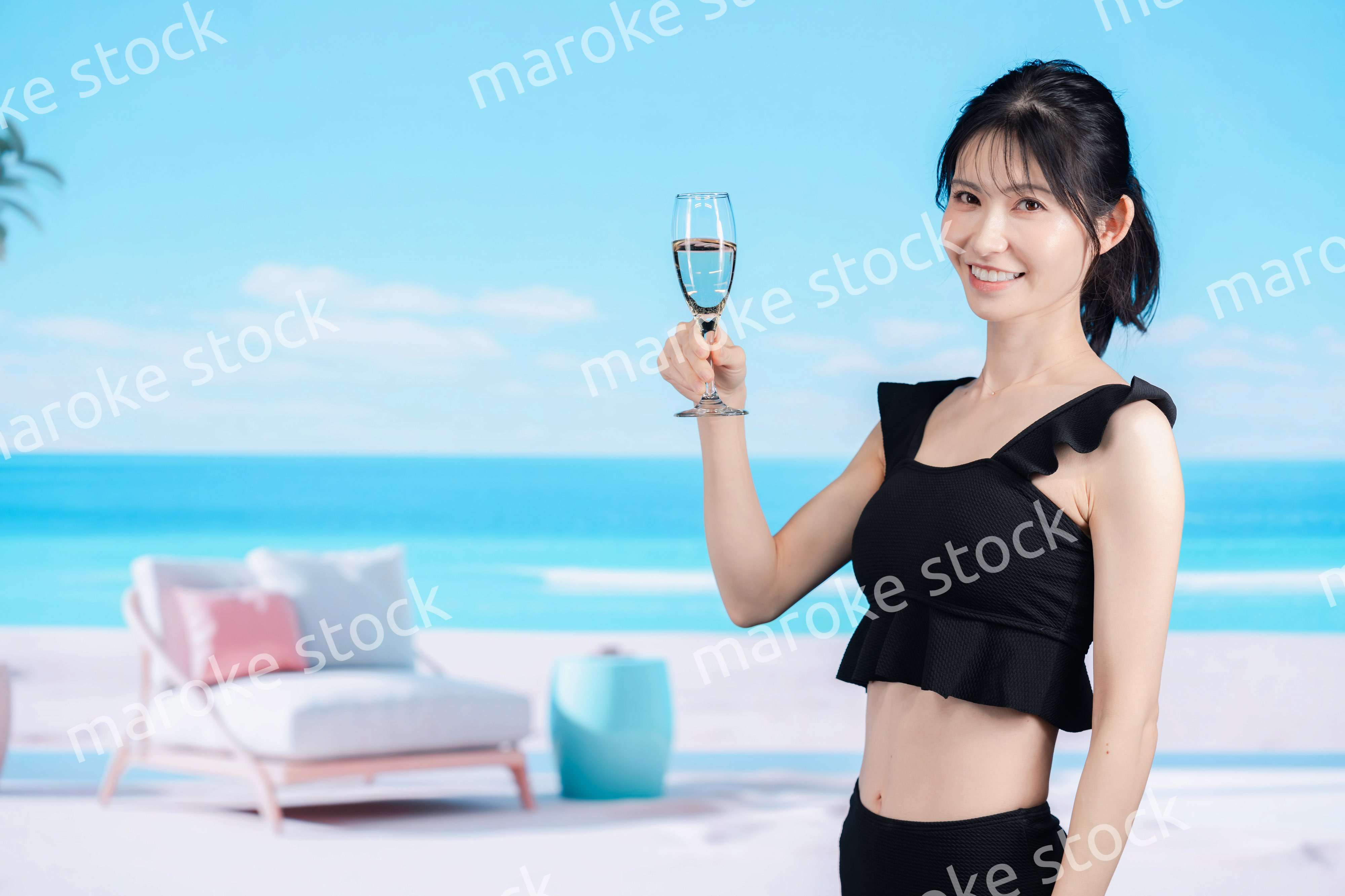 ビーチでスパークリングワインを飲む若い女性