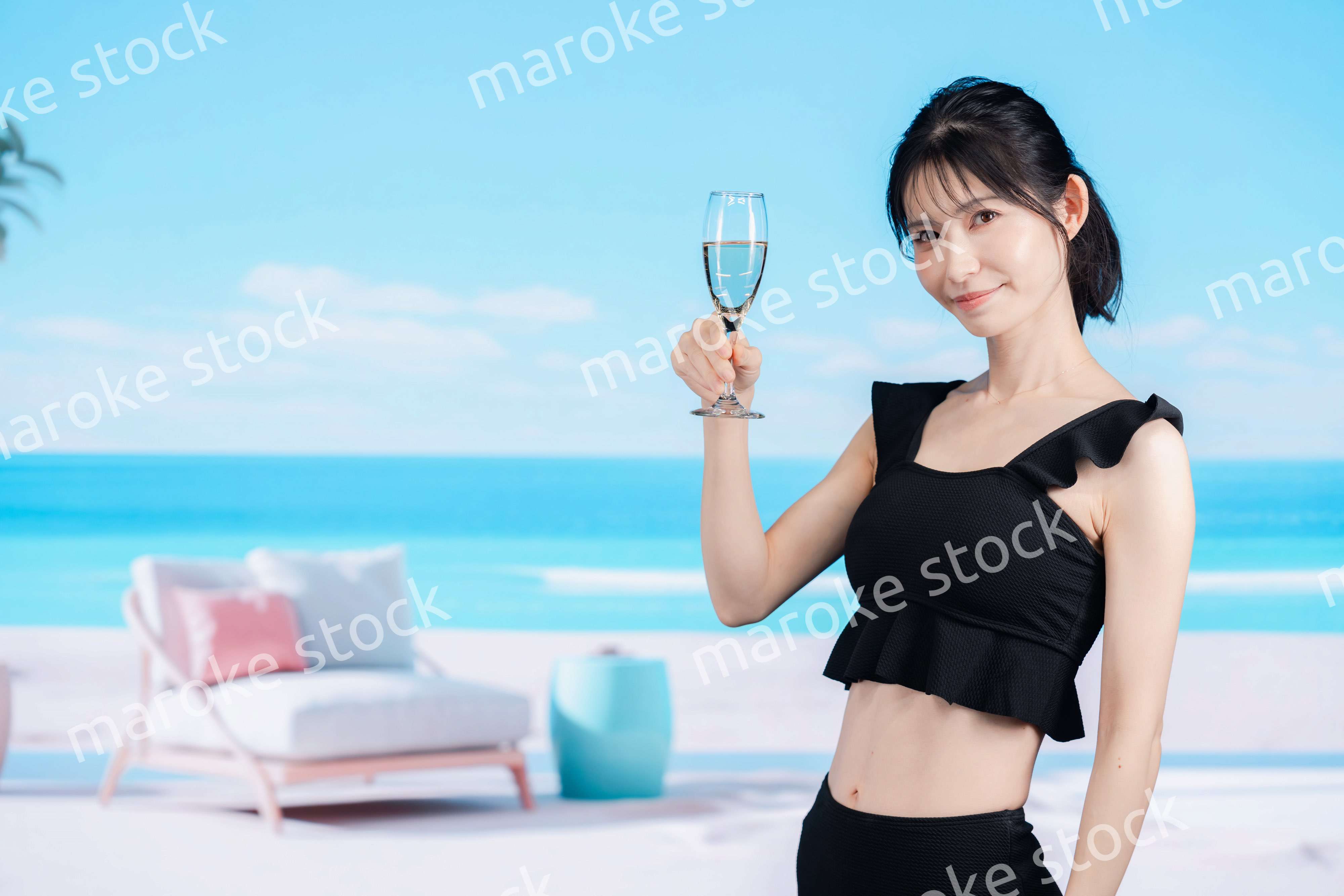 ビーチでスパークリングワインを飲む若い女性