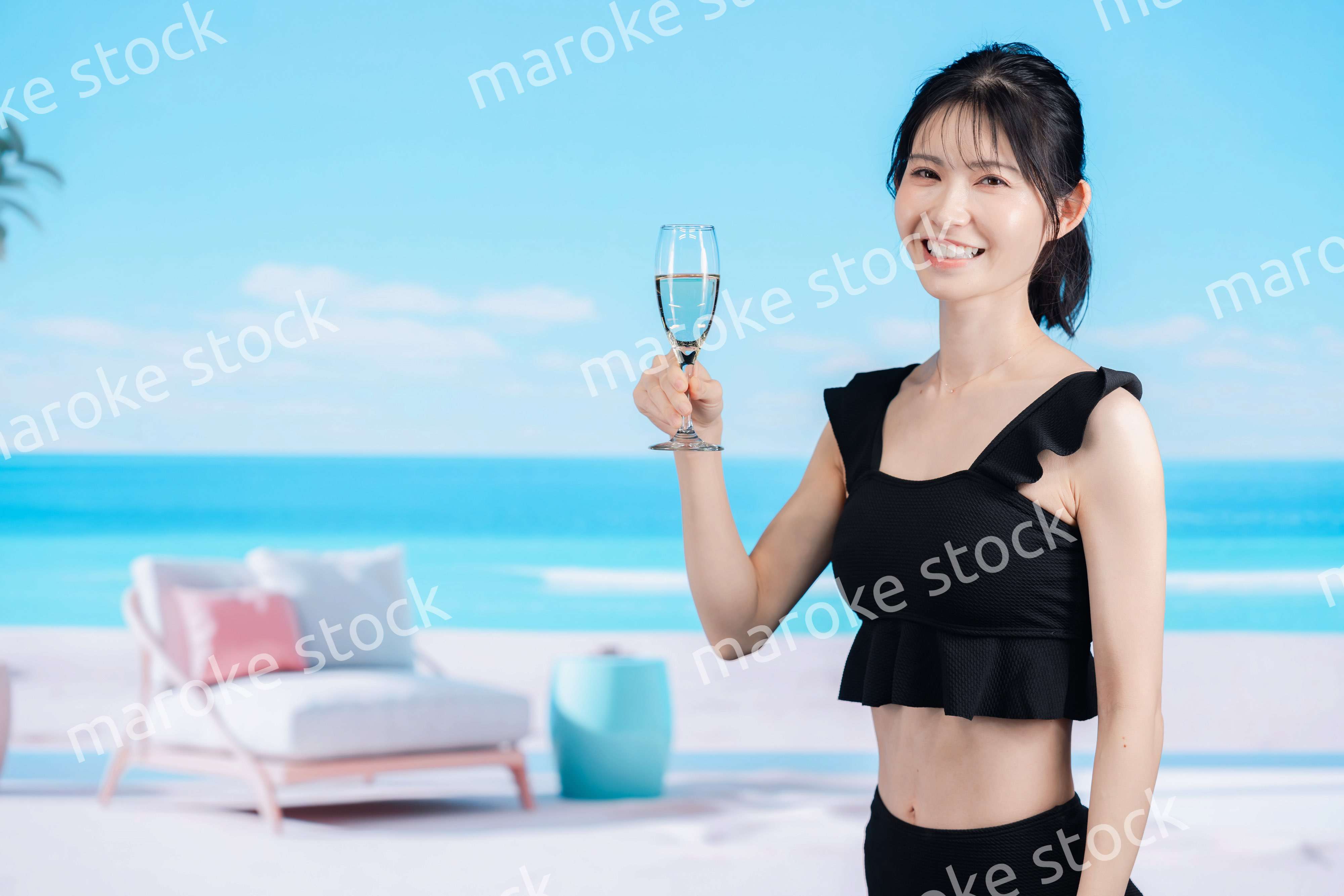 ビーチでスパークリングワインを飲む若い女性