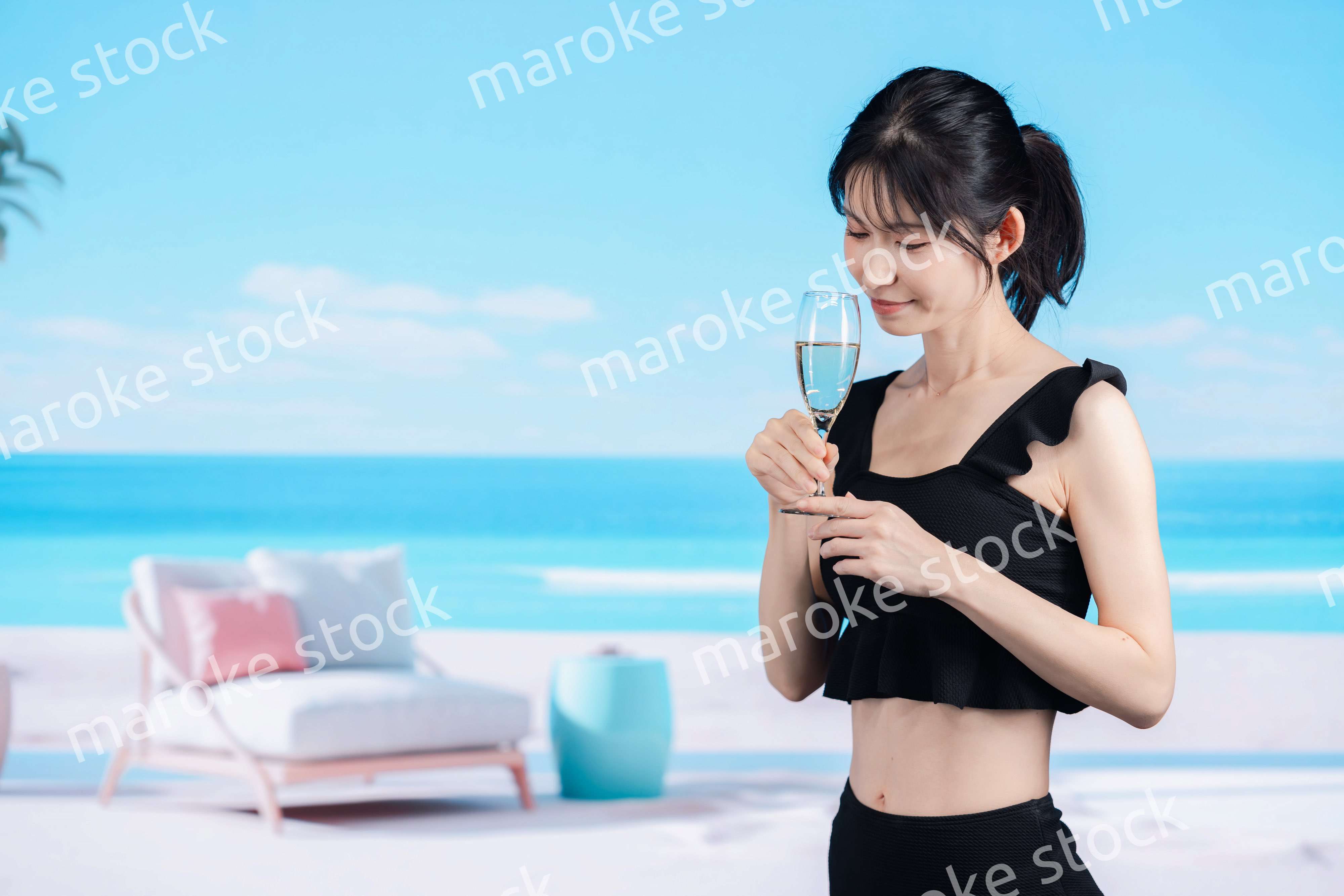 ビーチでスパークリングワインを飲む若い女性