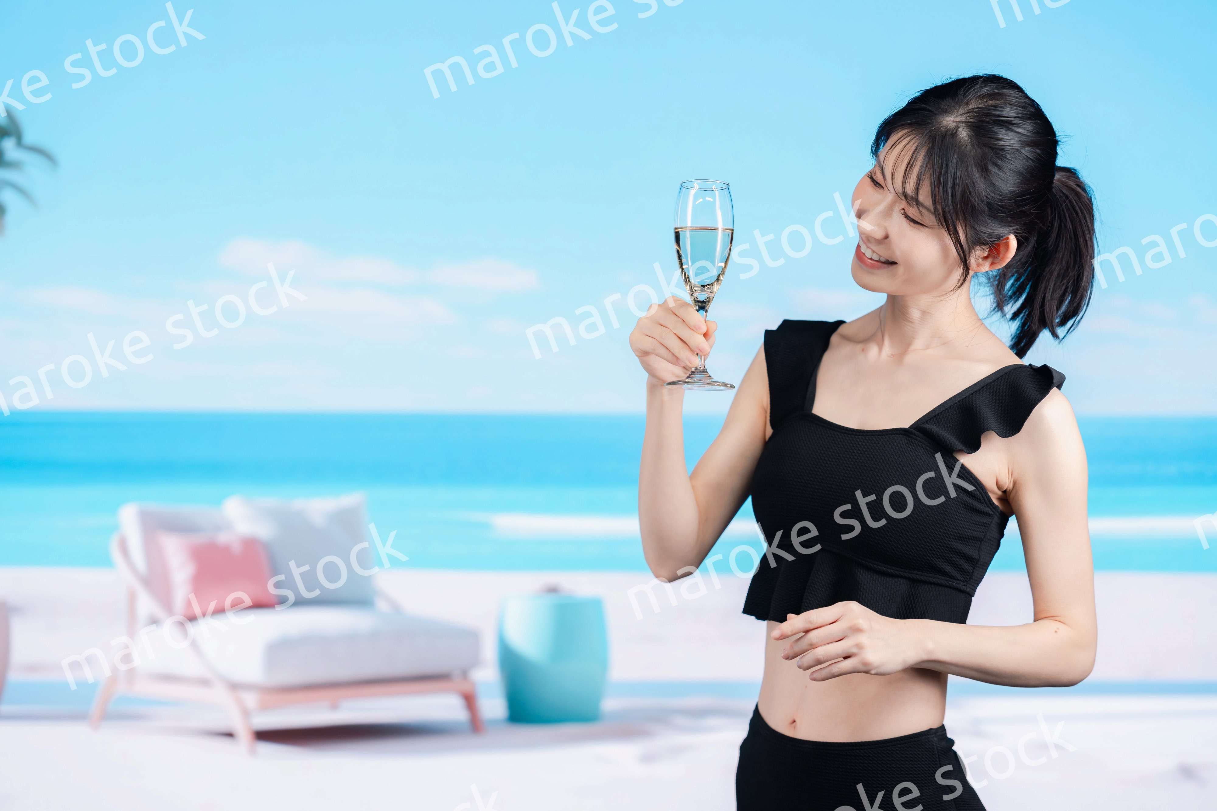 ビーチでスパークリングワインを飲む若い女性