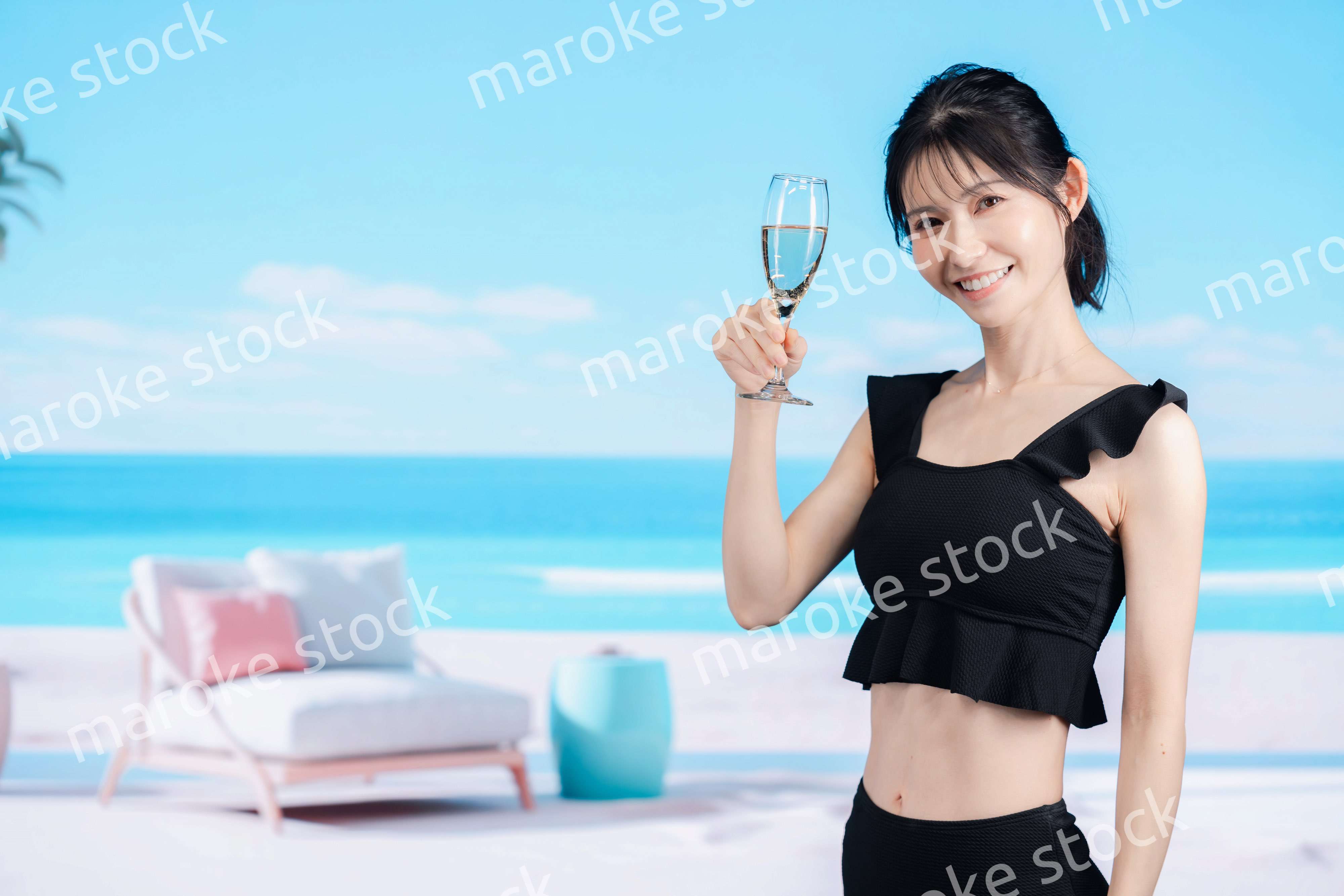 ビーチでスパークリングワインを飲む若い女性