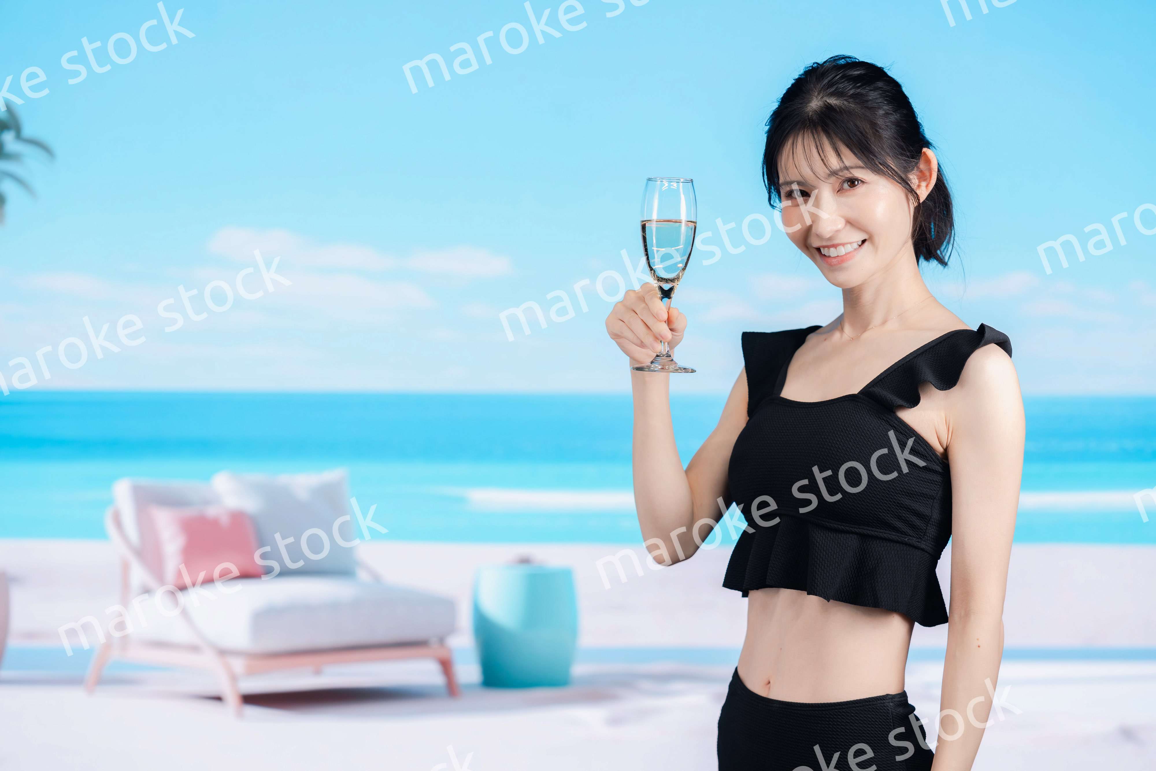 ビーチでスパークリングワインを飲む若い女性