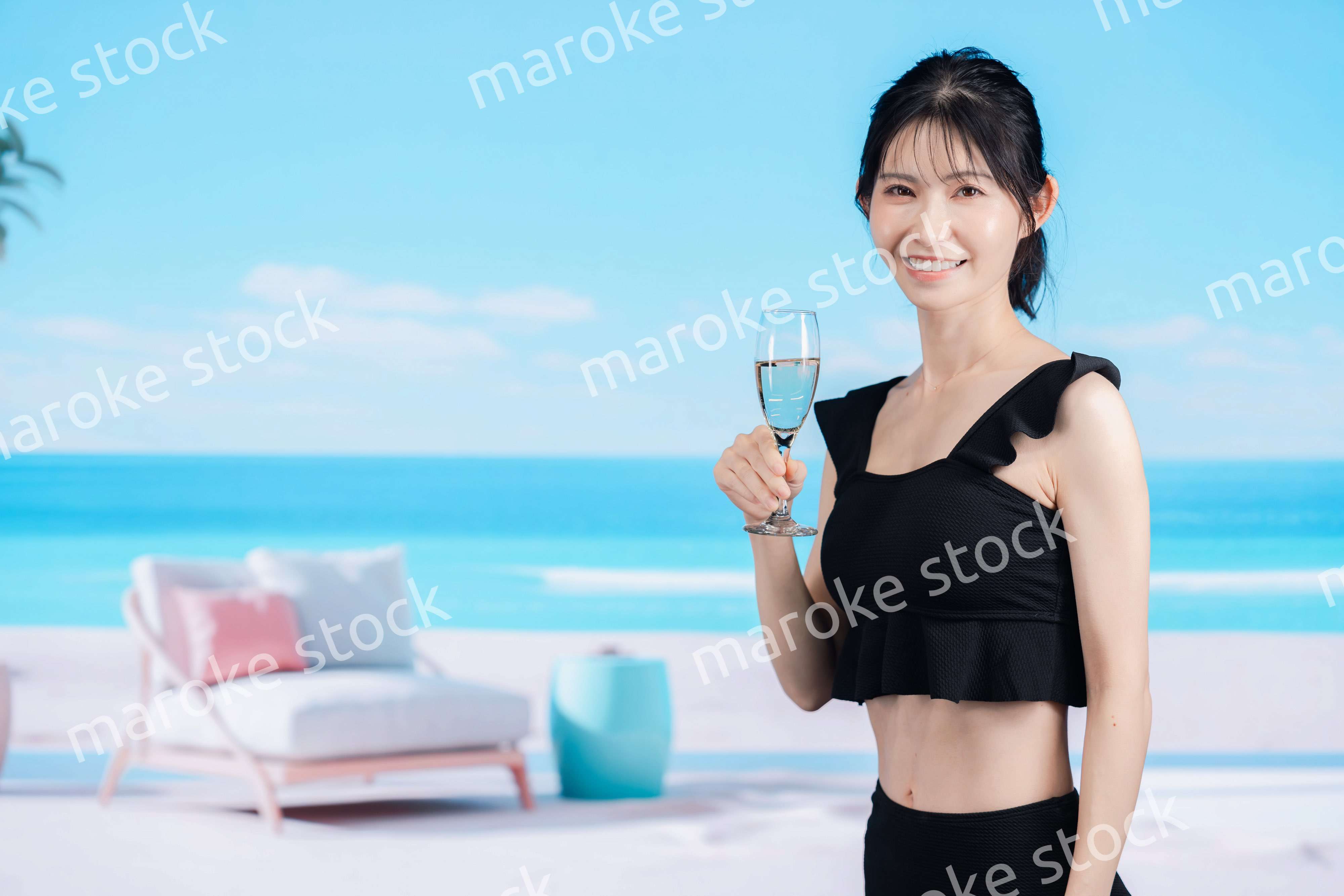 ビーチでスパークリングワインを飲む若い女性