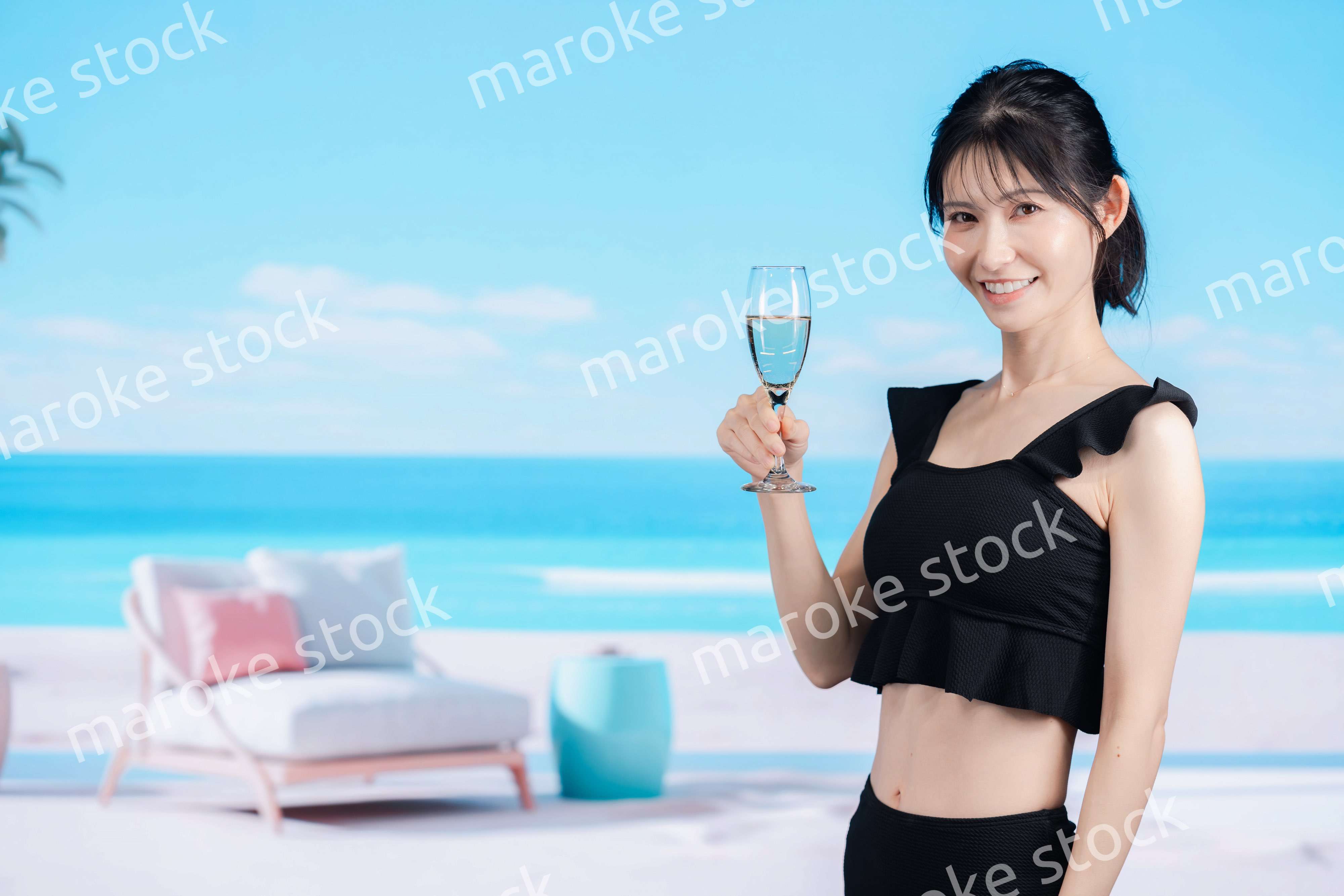 ビーチでスパークリングワインを飲む若い女性