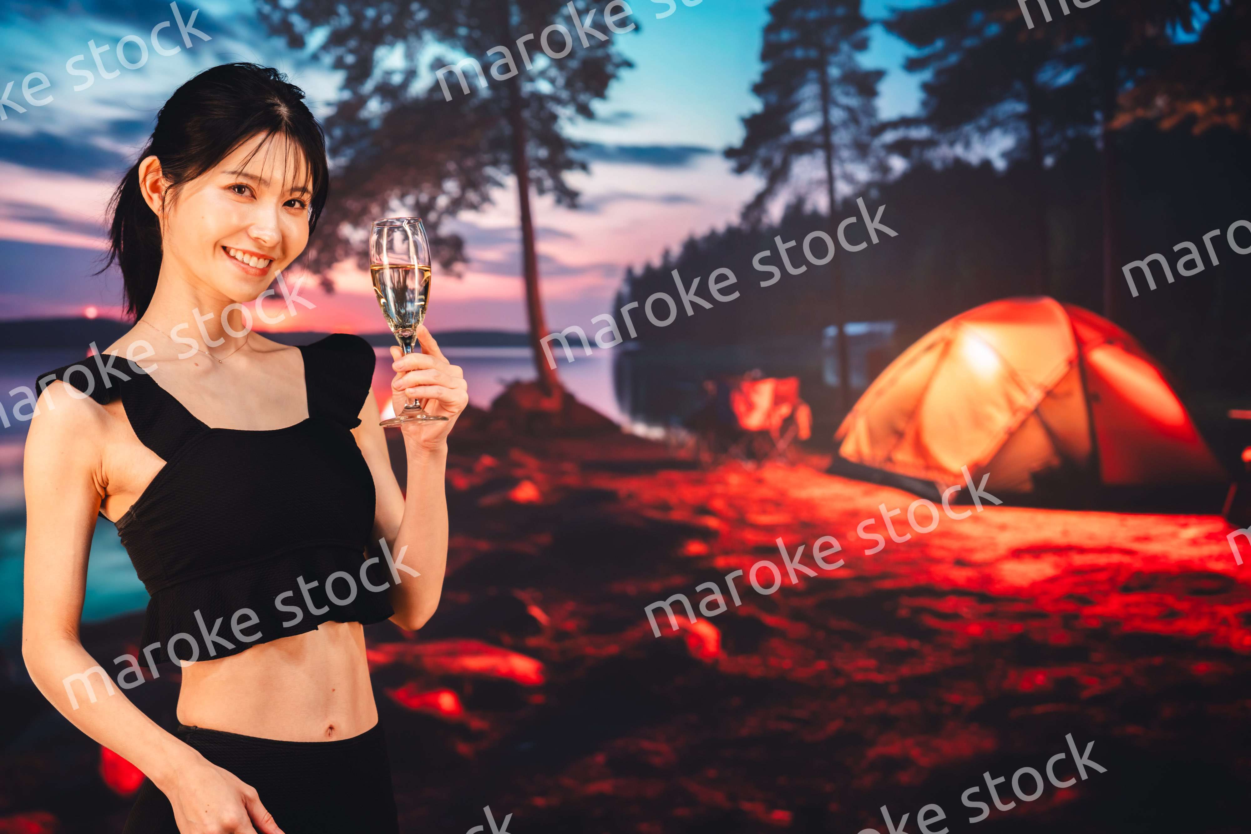 キャンプをしながらスパークリングワインを飲む女性