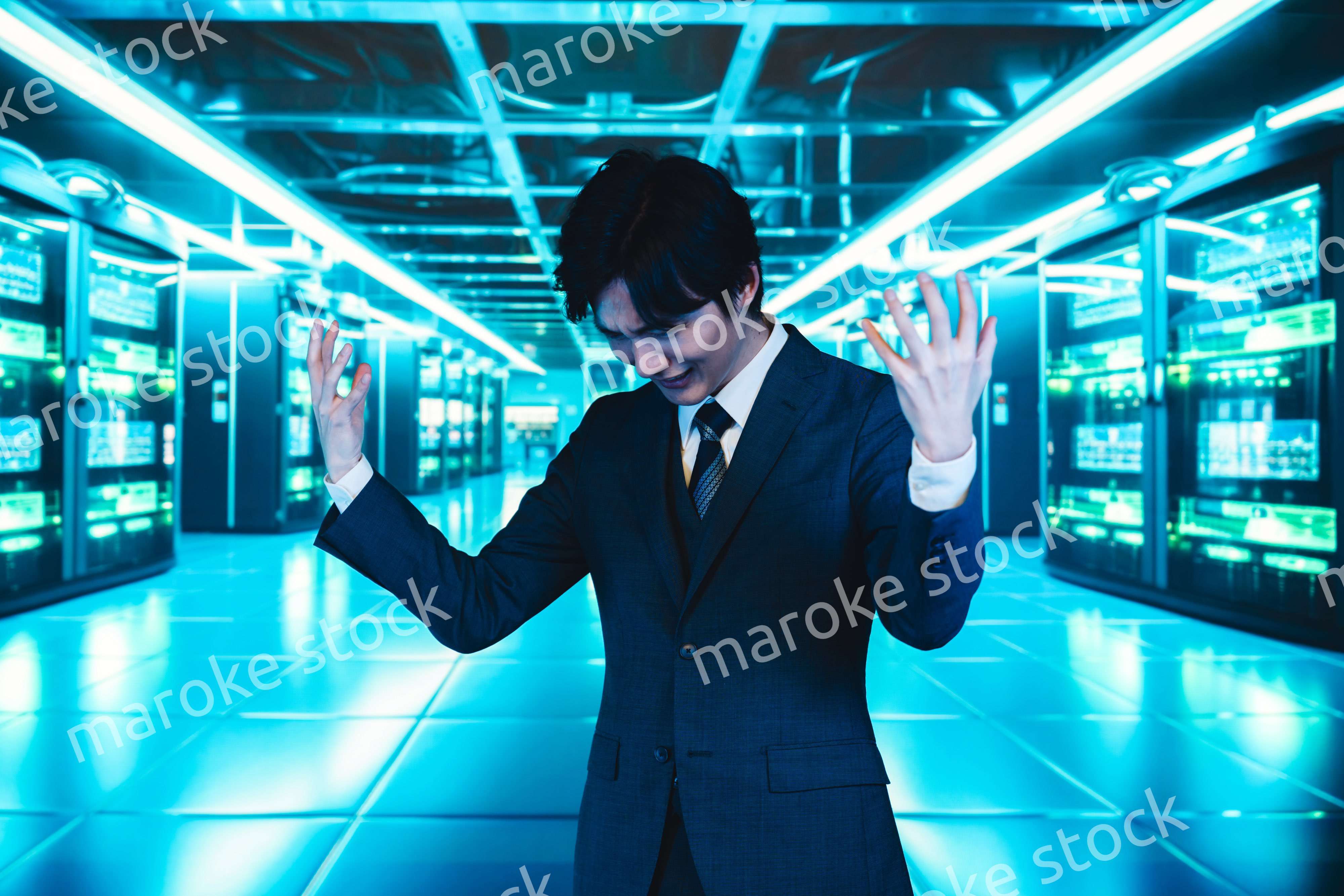 サーバールームで頭を抱えるビジネスマン