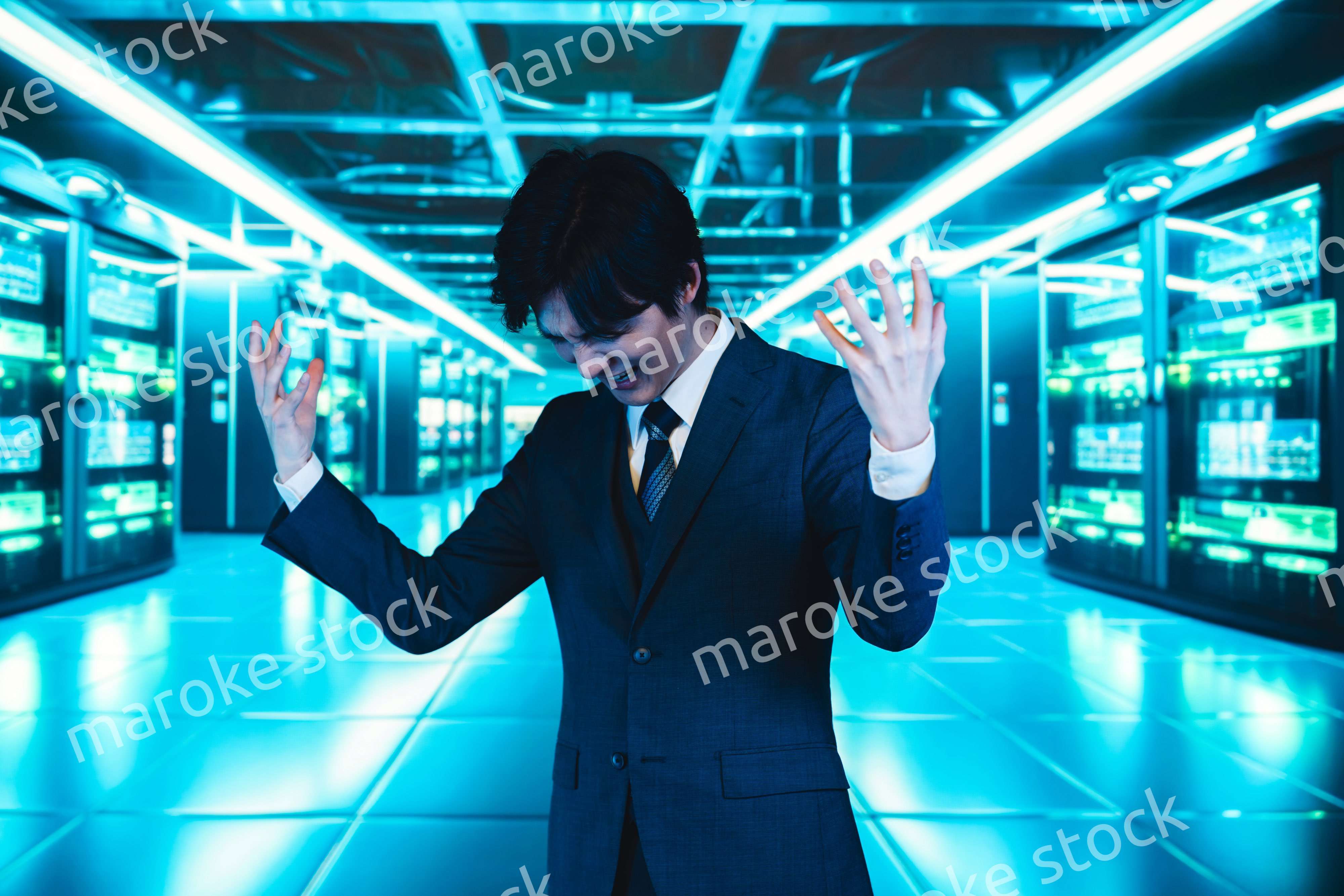 サーバールームで頭を抱えるビジネスマン