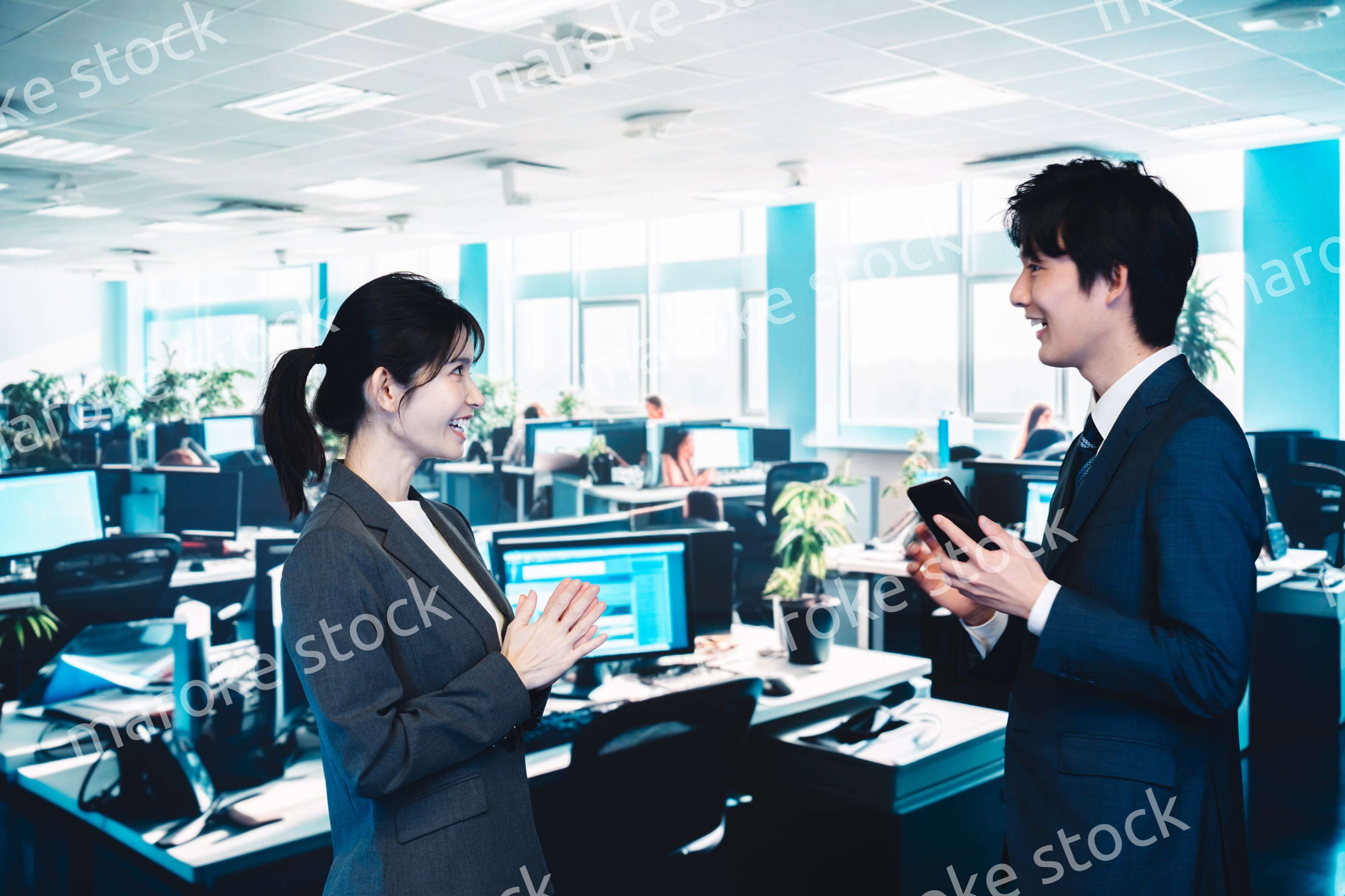 オフィスで楽しく話す男女のビジネスパーソン