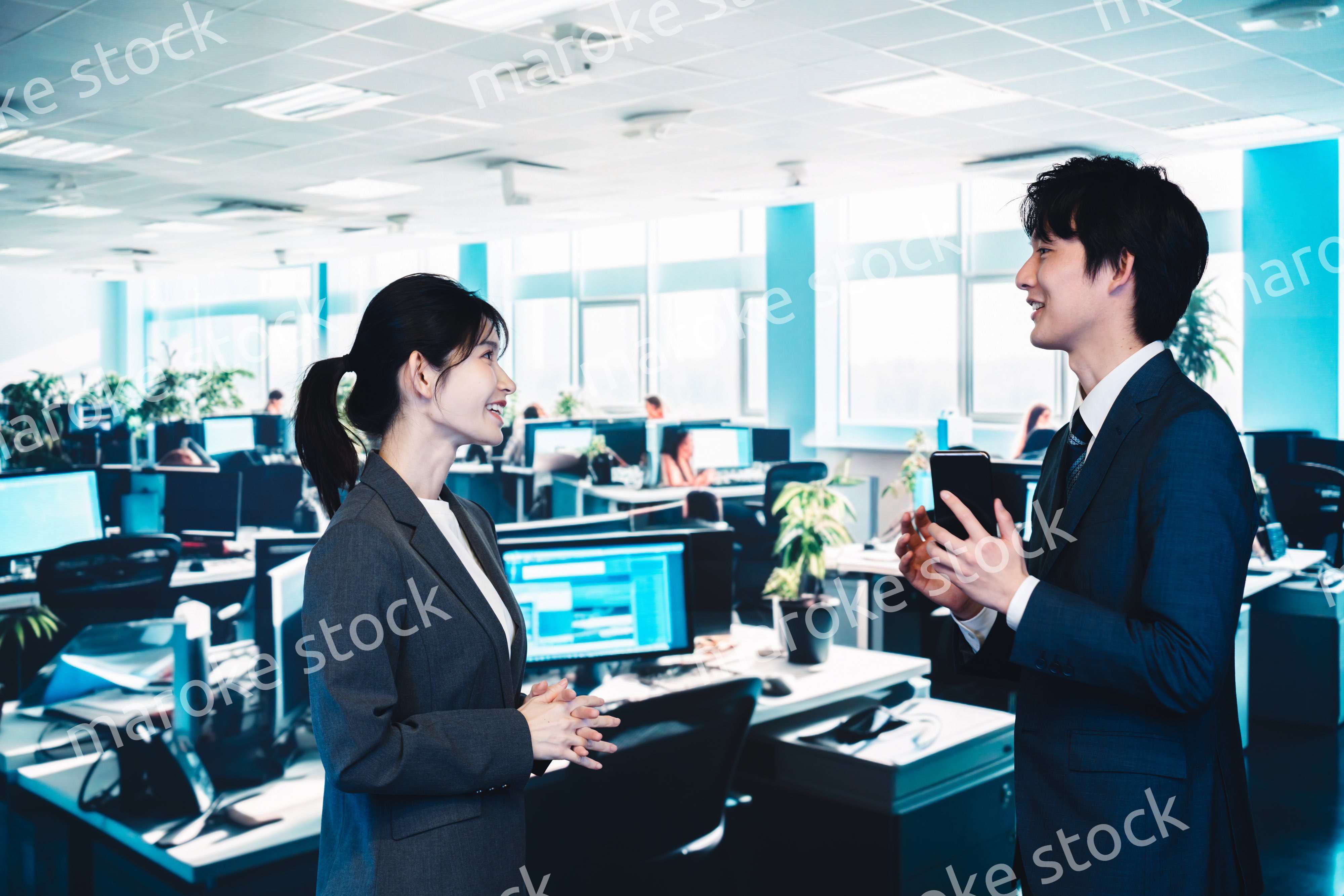 オフィスで楽しく話す男女のビジネスパーソン