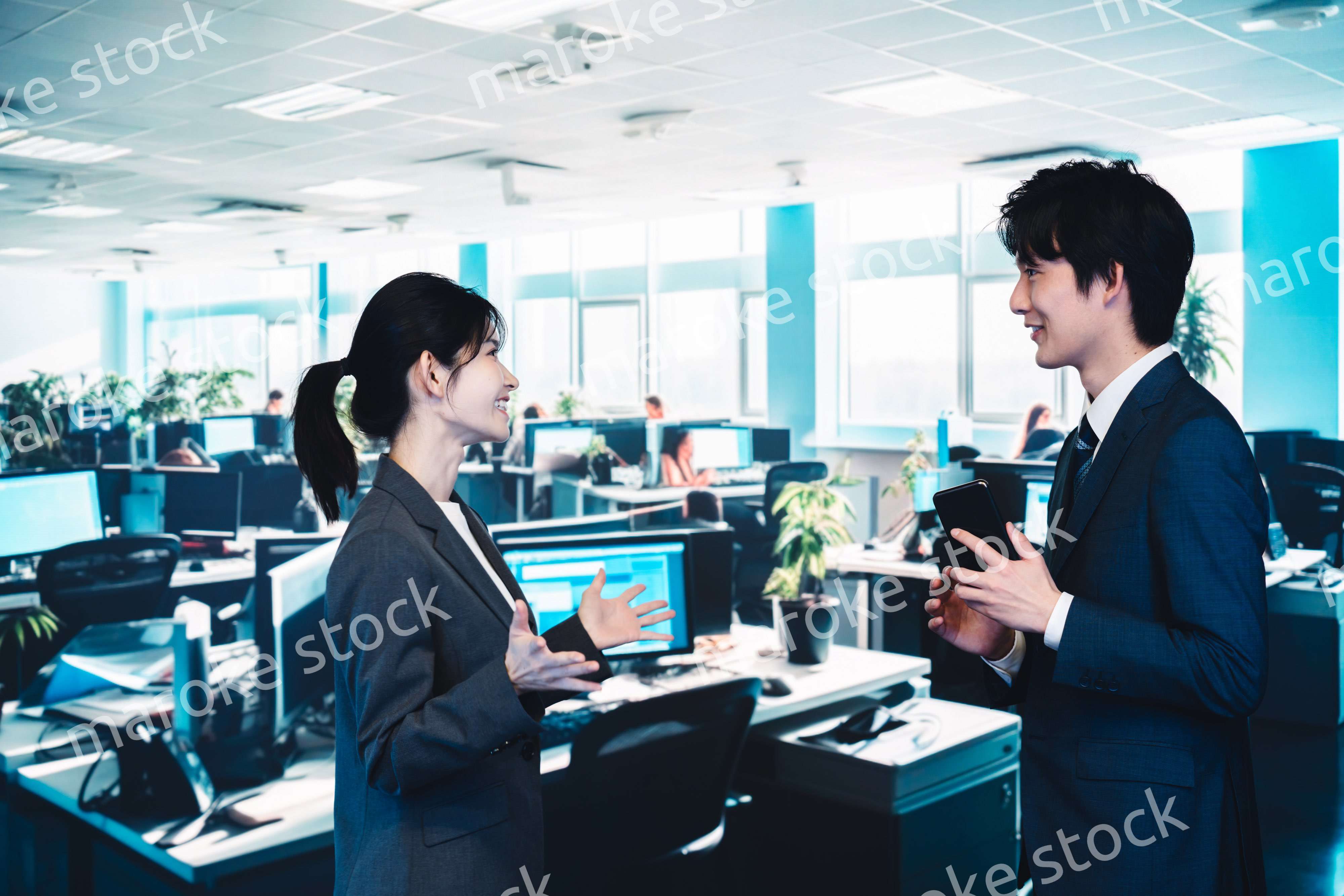 オフィスで楽しく話す男女のビジネスパーソン