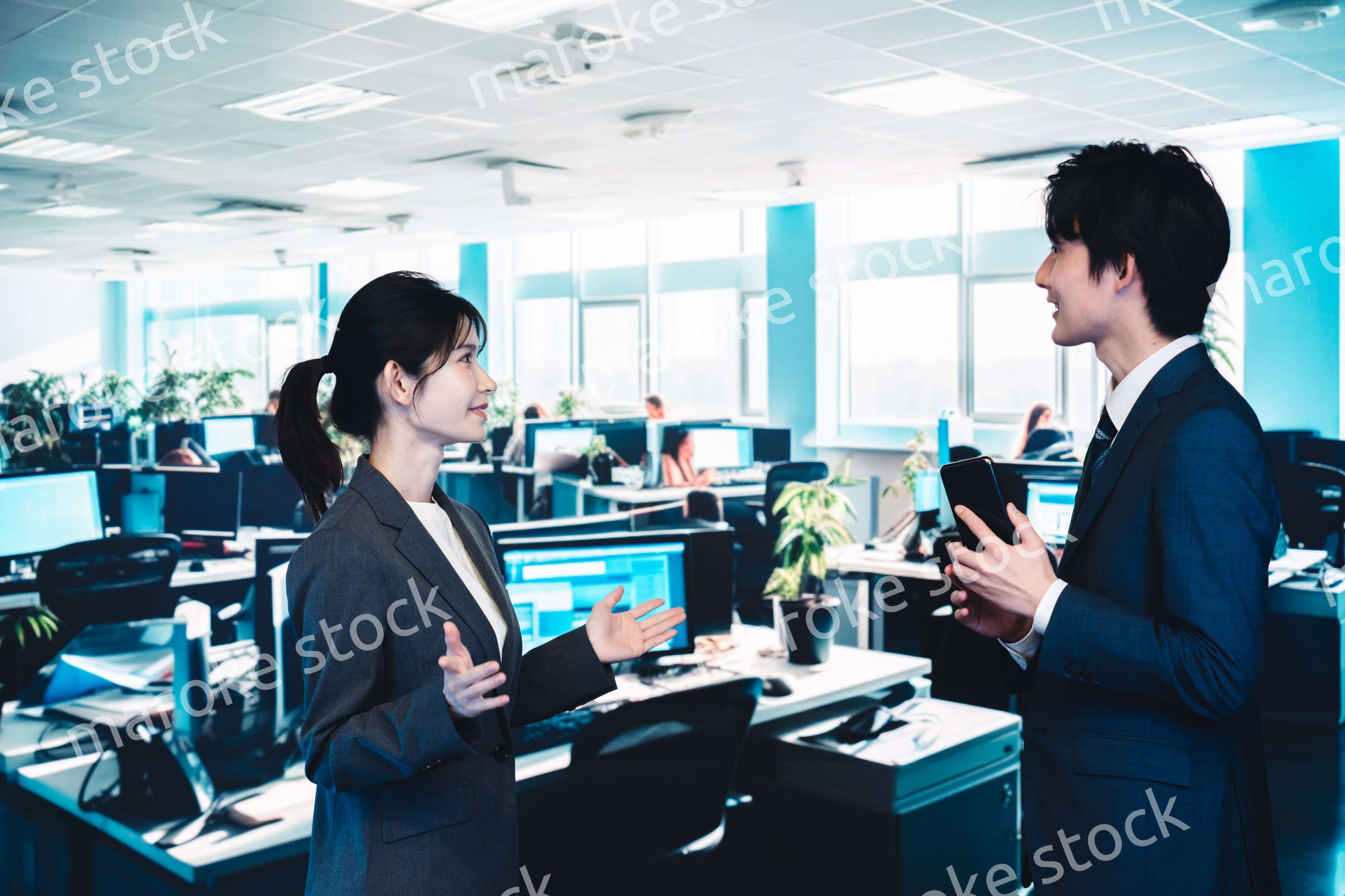 オフィスで楽しく話す男女のビジネスパーソン