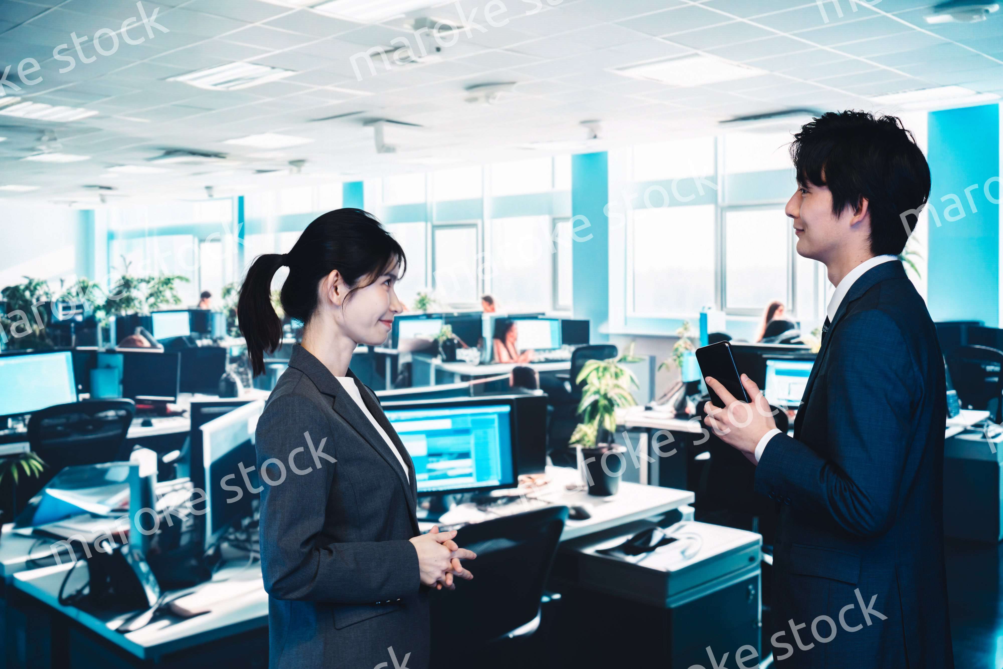 オフィスで楽しく話す男女のビジネスパーソン