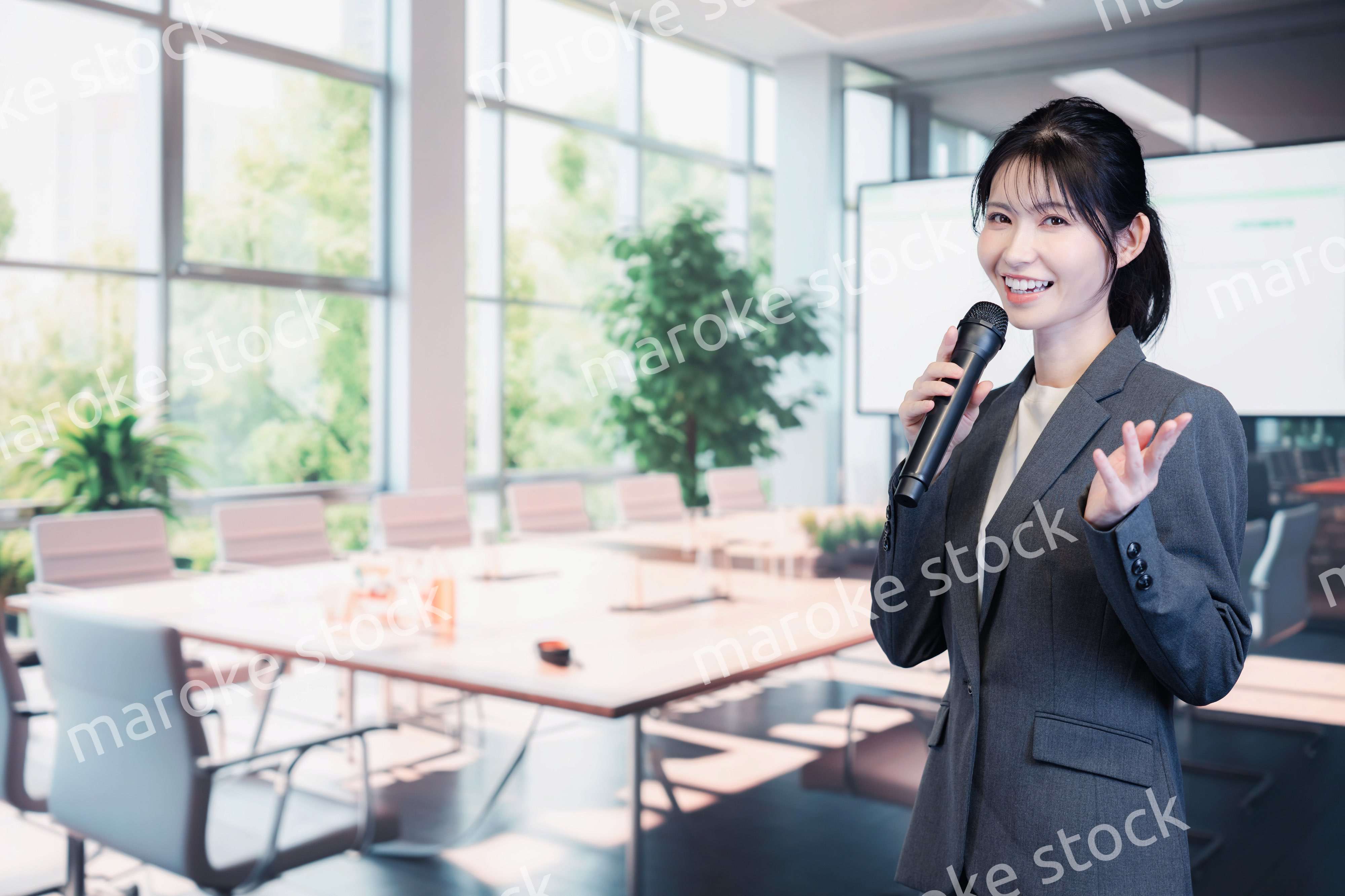 マイクで話すビジネスウーマン