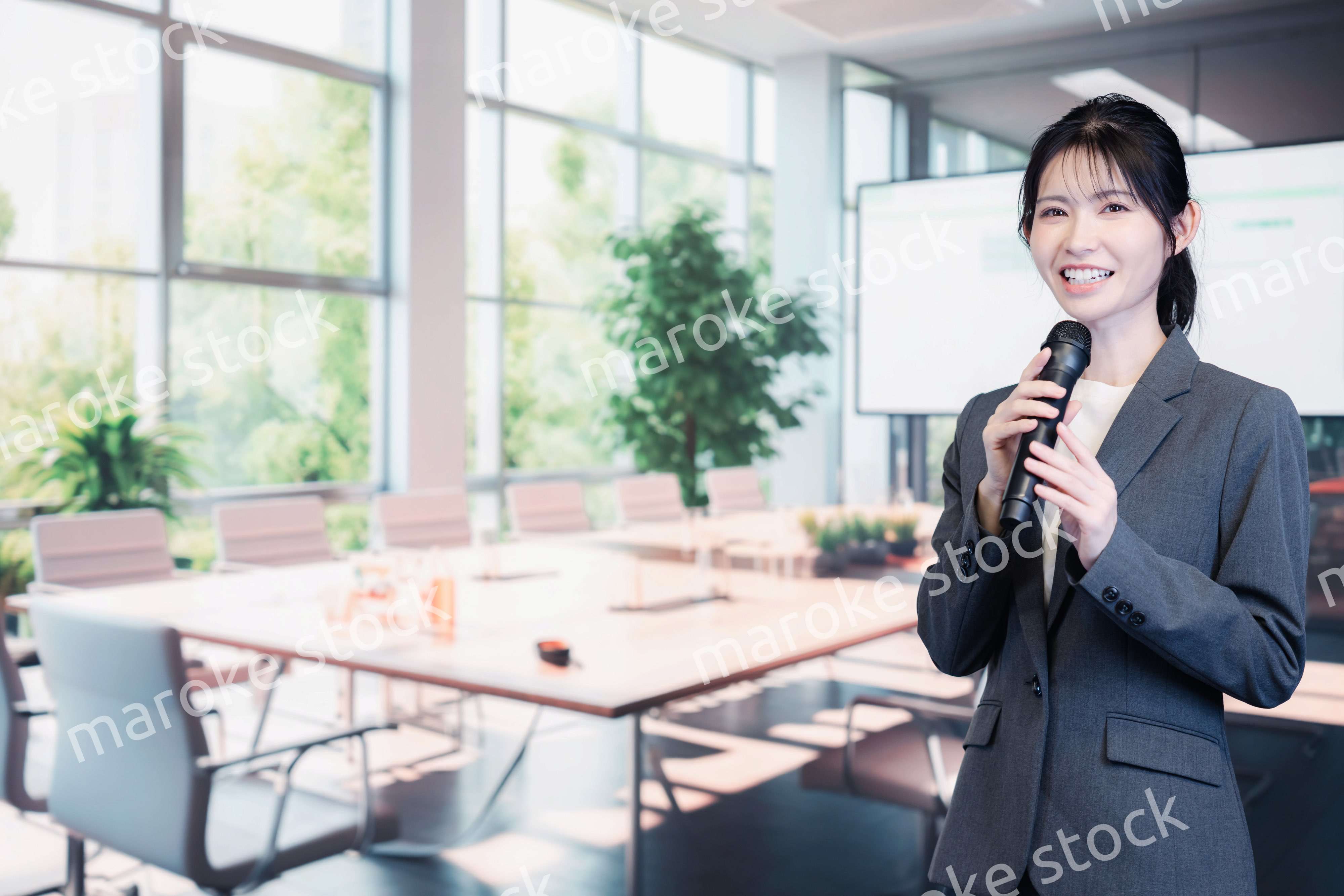 マイクで話すビジネスウーマン