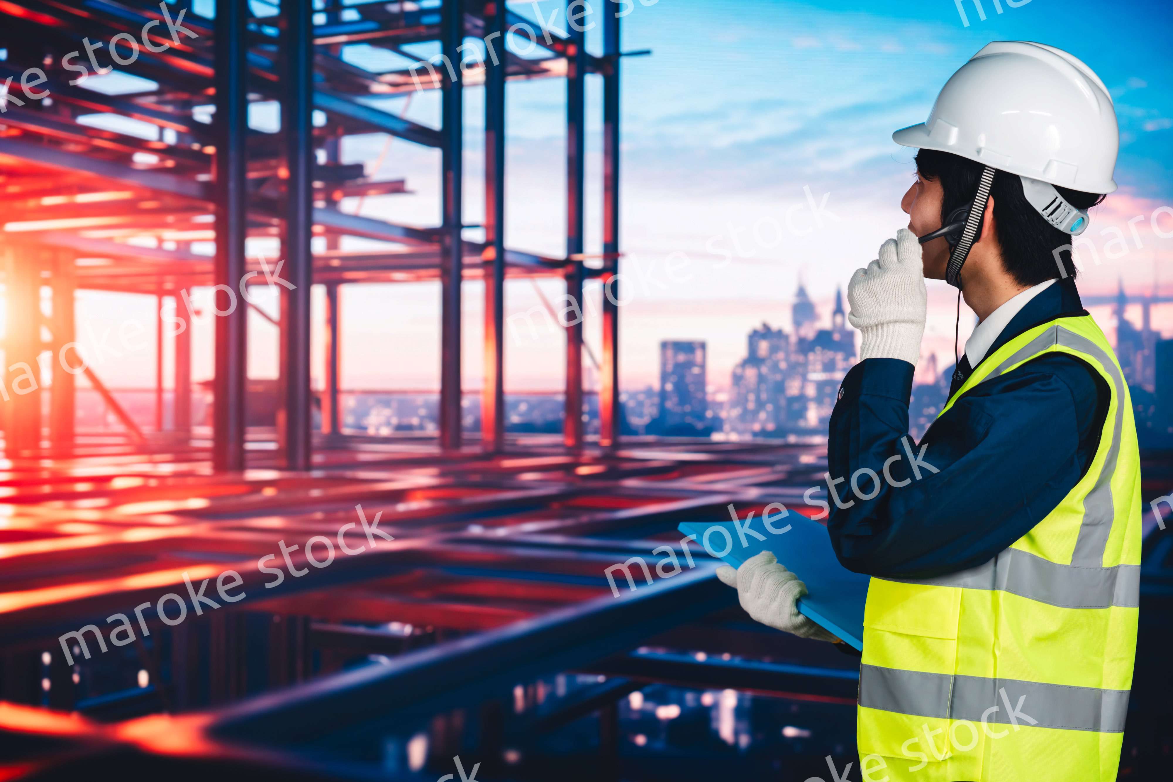高層ビルの建築現場で作業をする若い男性