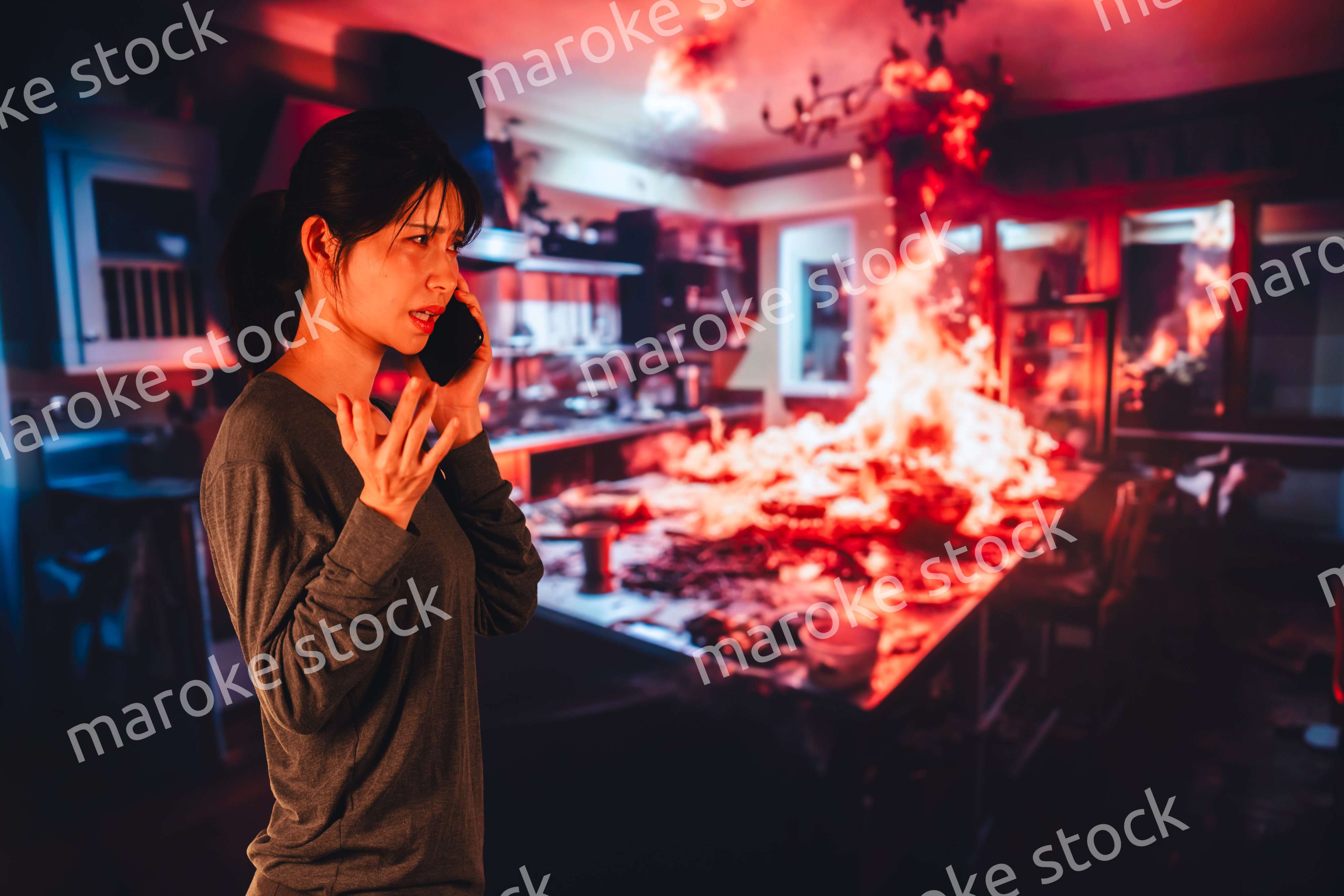 火災が発生し消防に通報をする若い女性