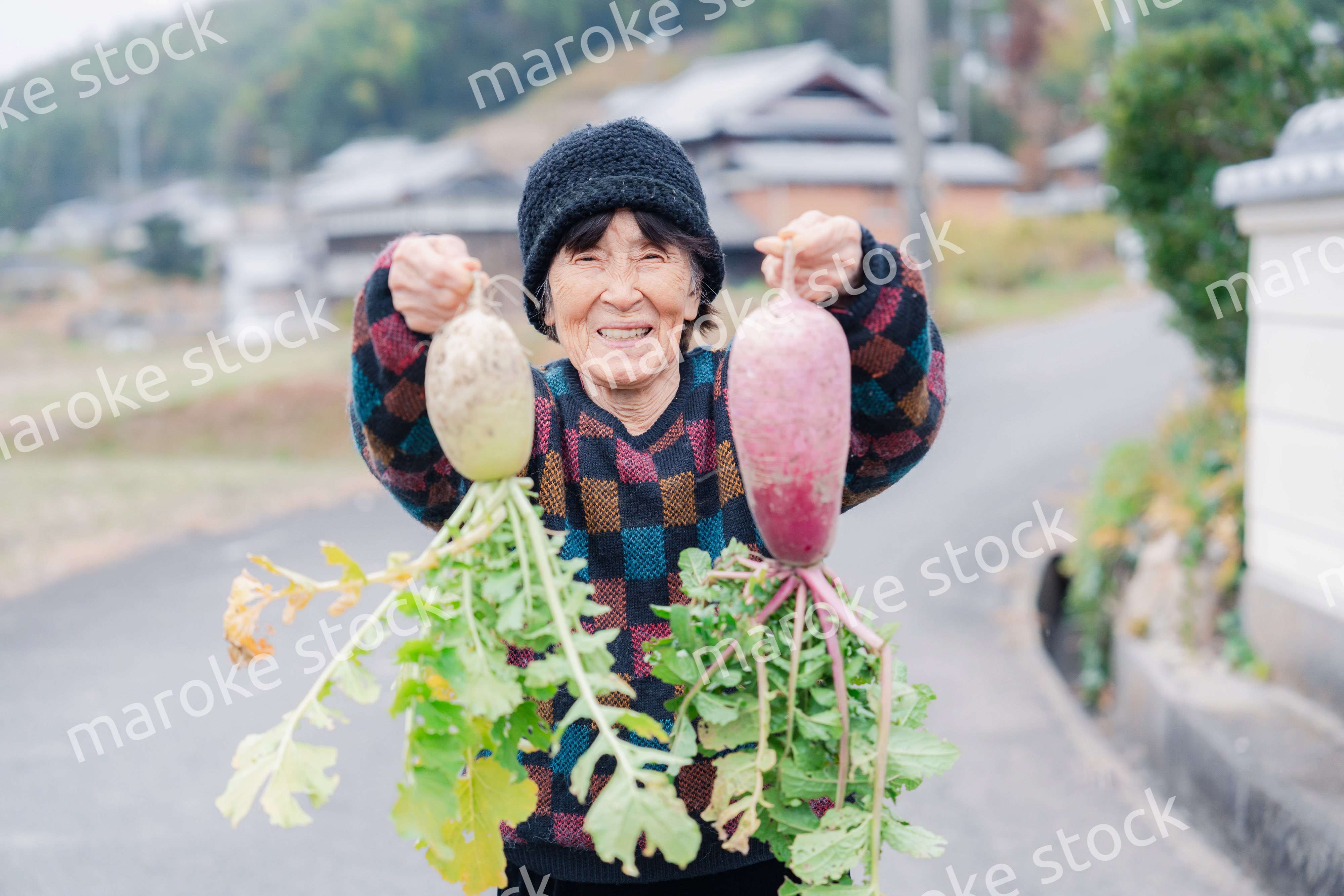 畑で野菜を持つ高齢の女性