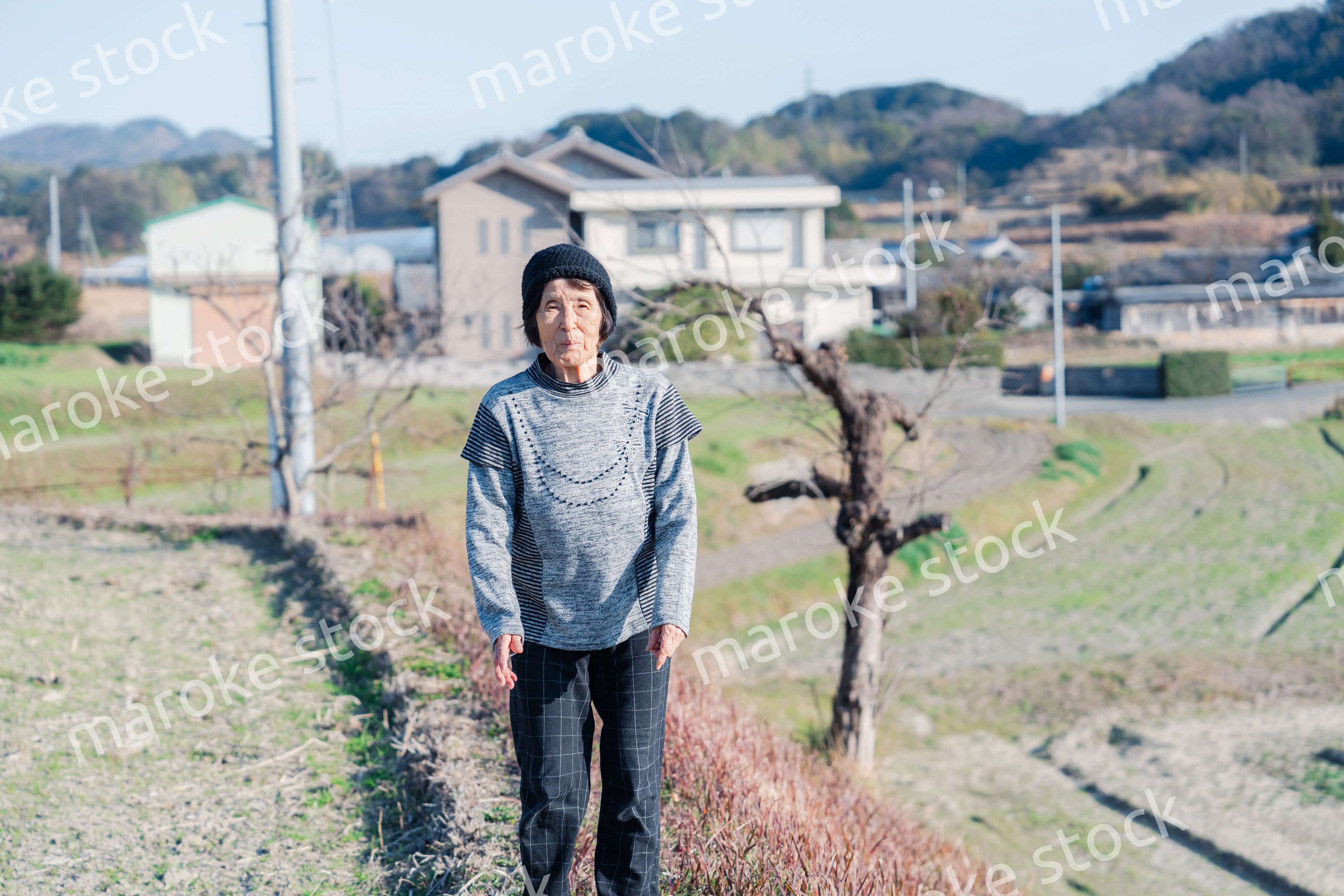 田舎の道を散歩する高齢の女性