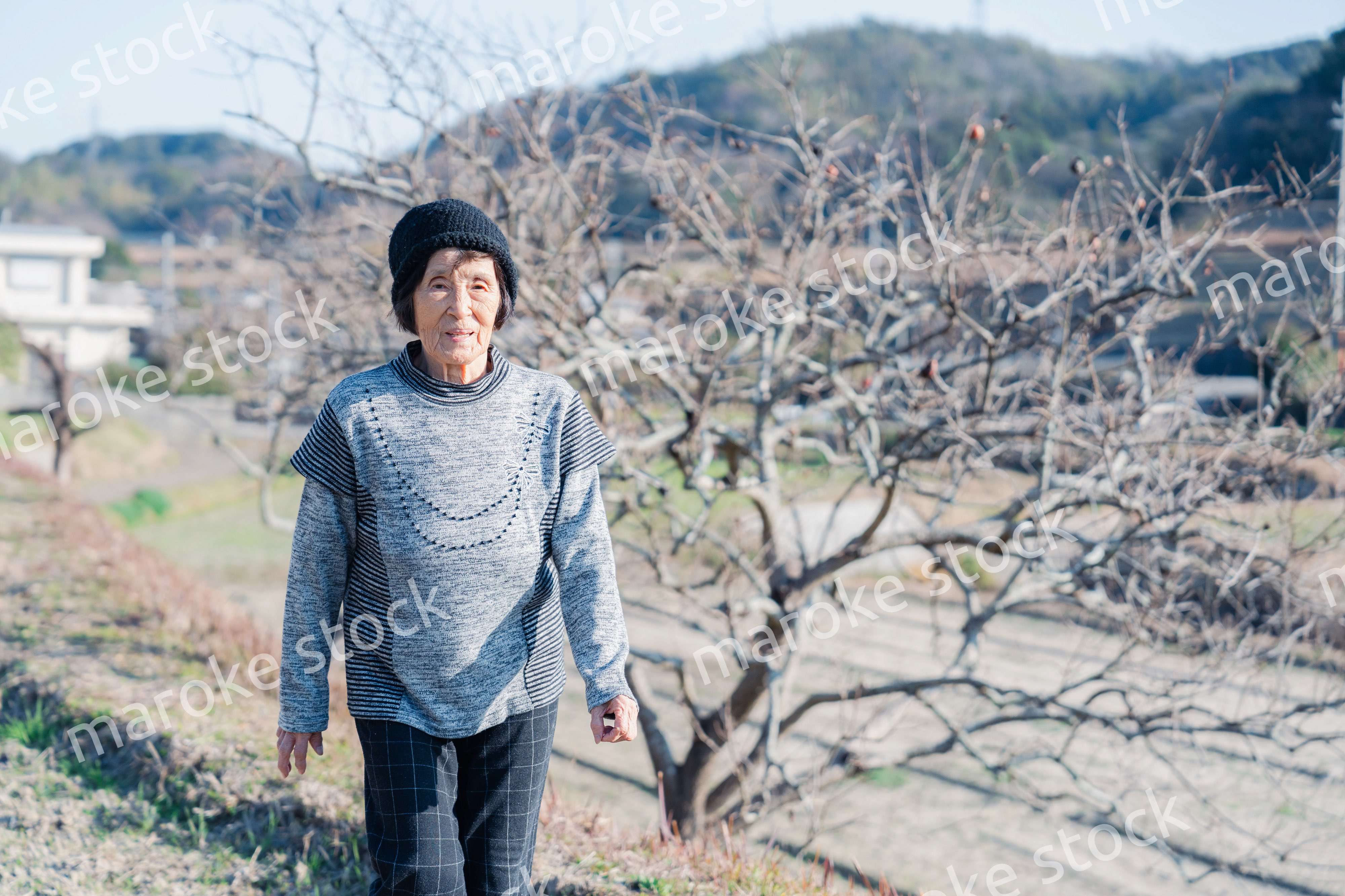 田舎の道を散歩する高齢の女性