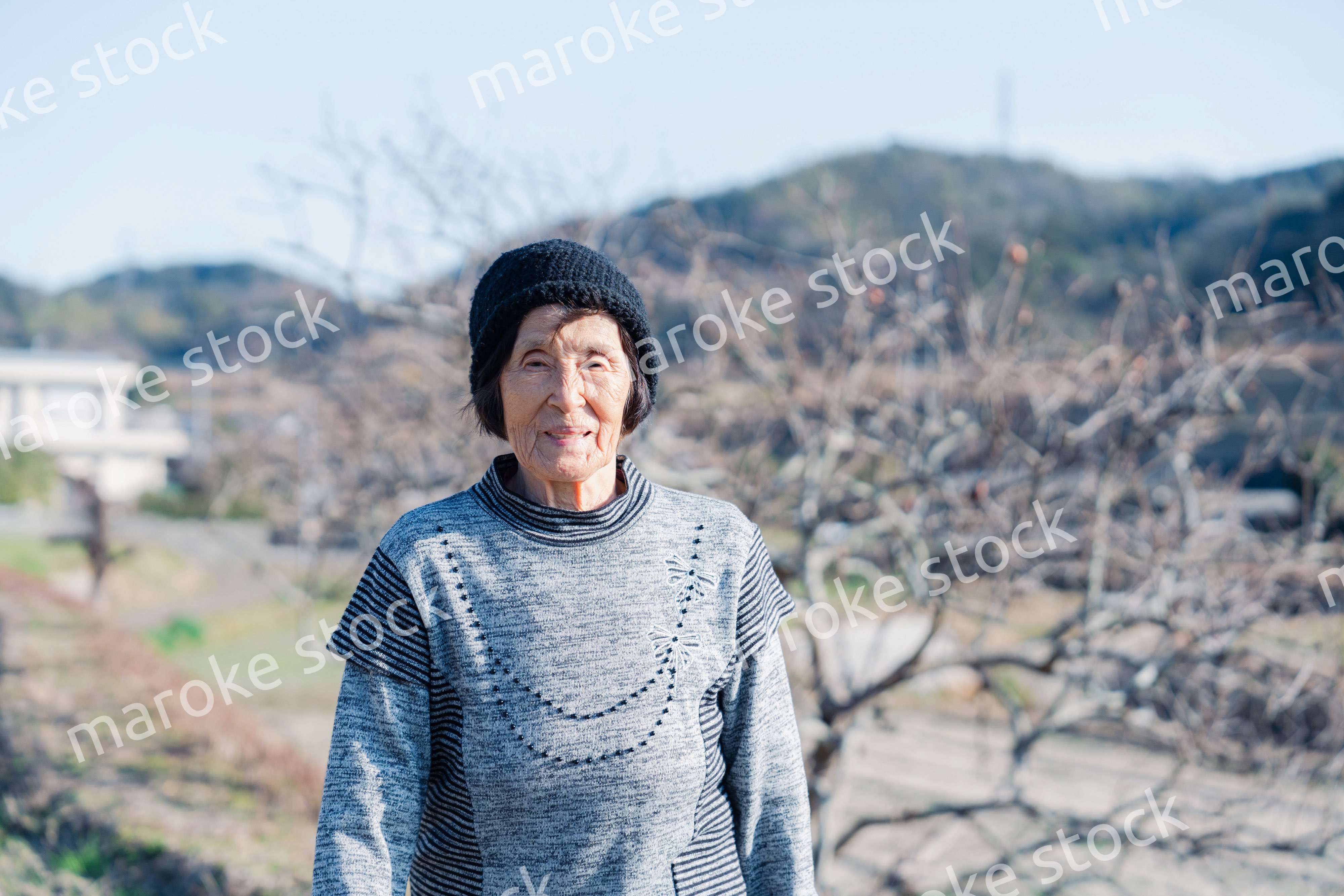 田舎の道を散歩する高齢の女性