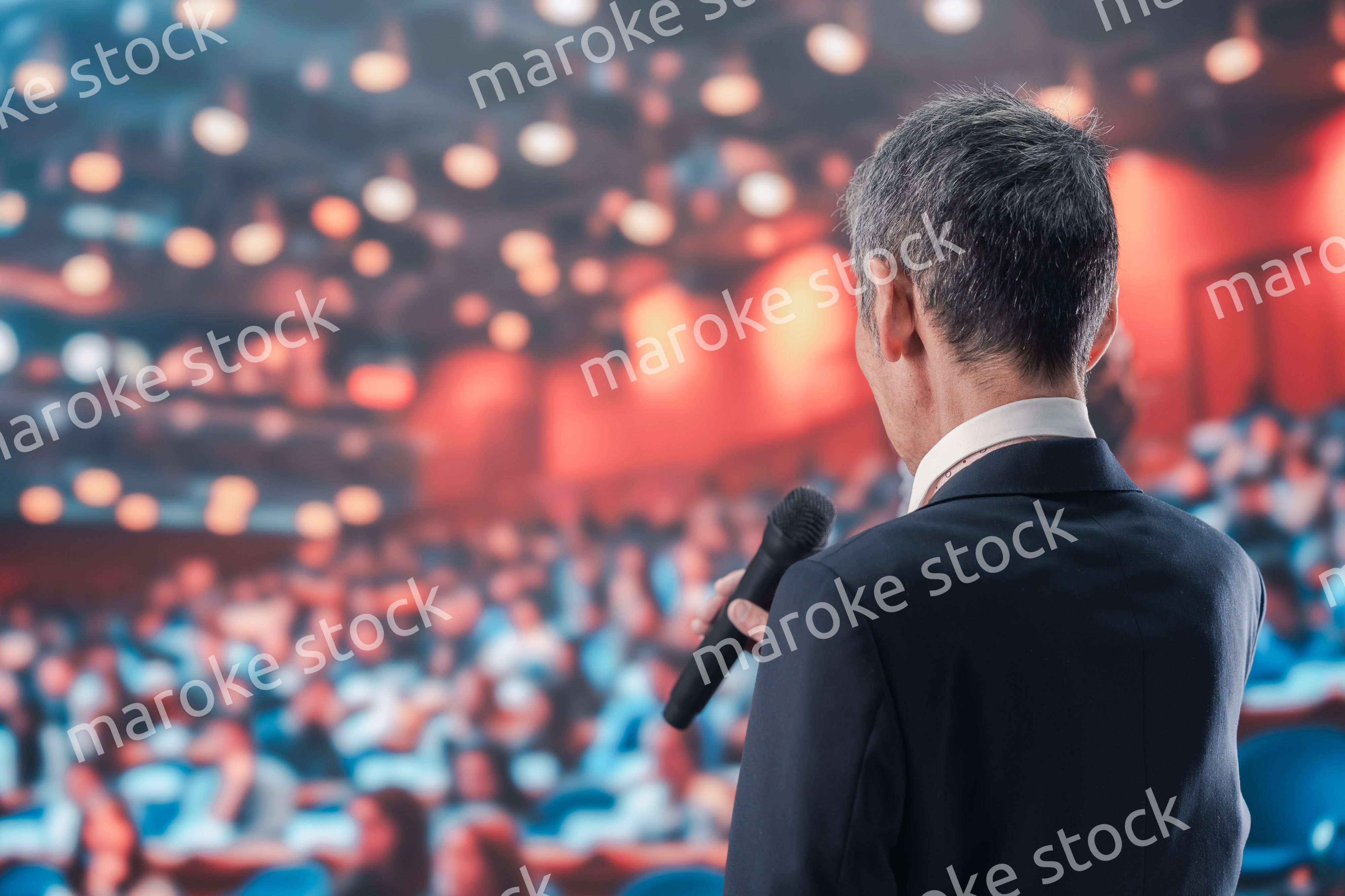 大勢の聴衆の前で話す男性
