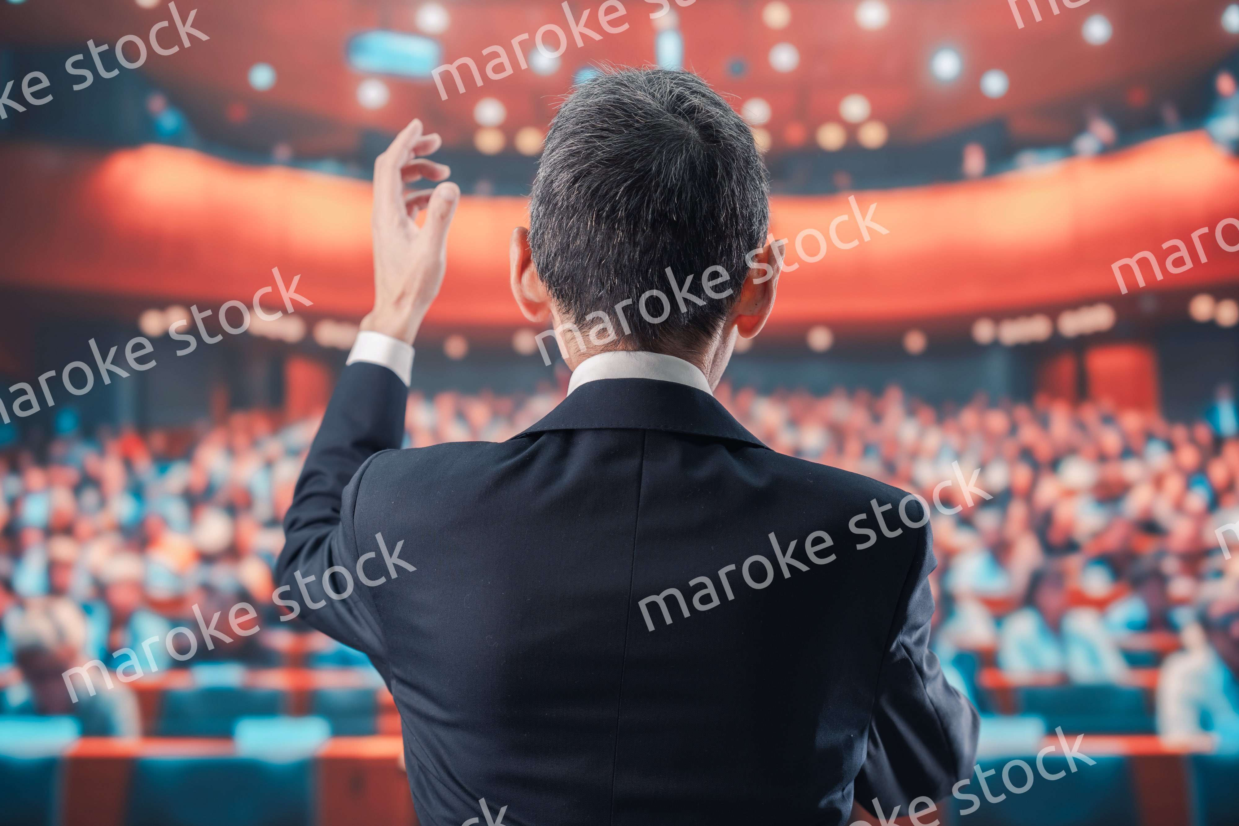 大勢の聴衆の前で話す男性