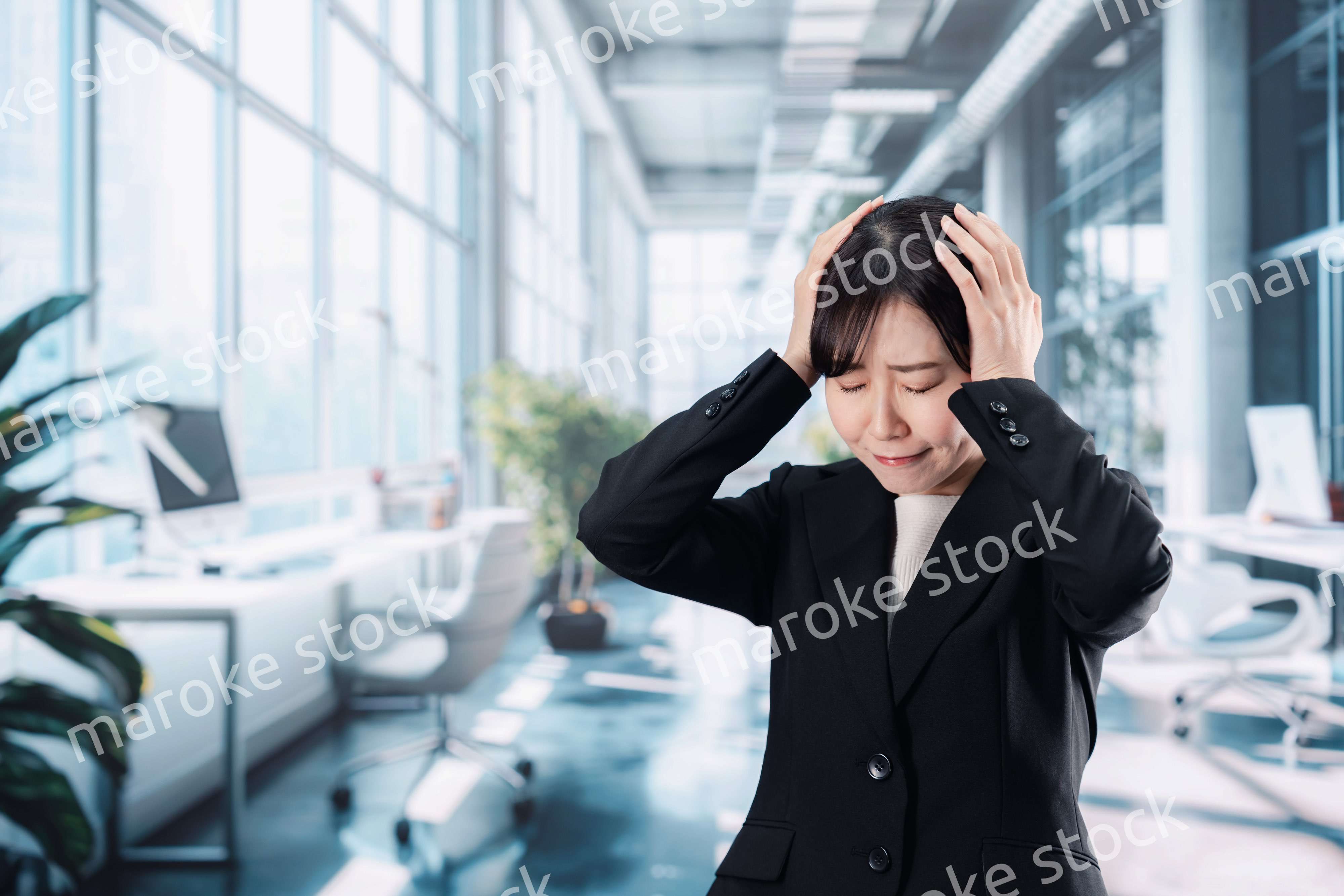 オフィスで頭を抱えるビジネスウーマン
